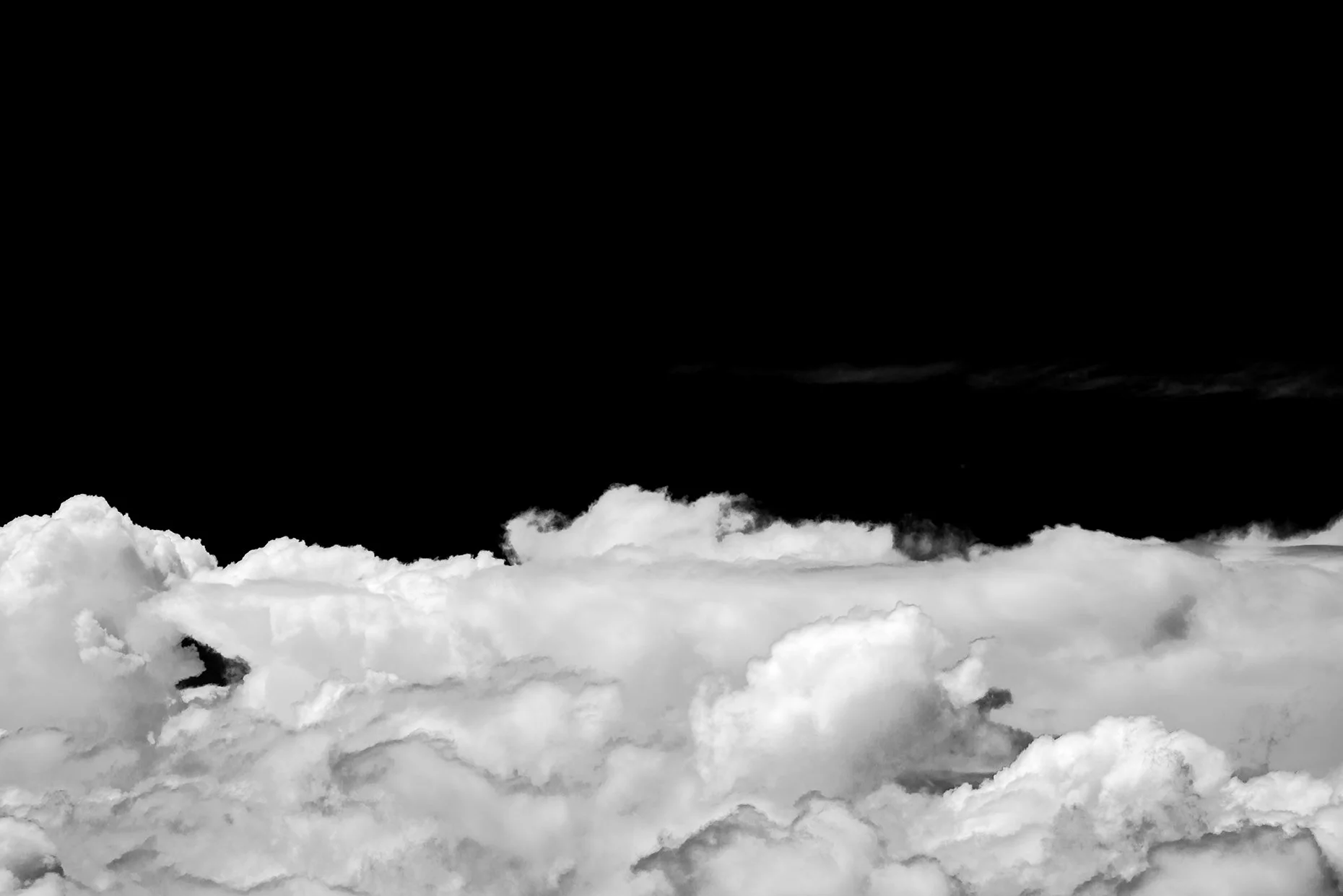 black and white photograph of sky above the clouds