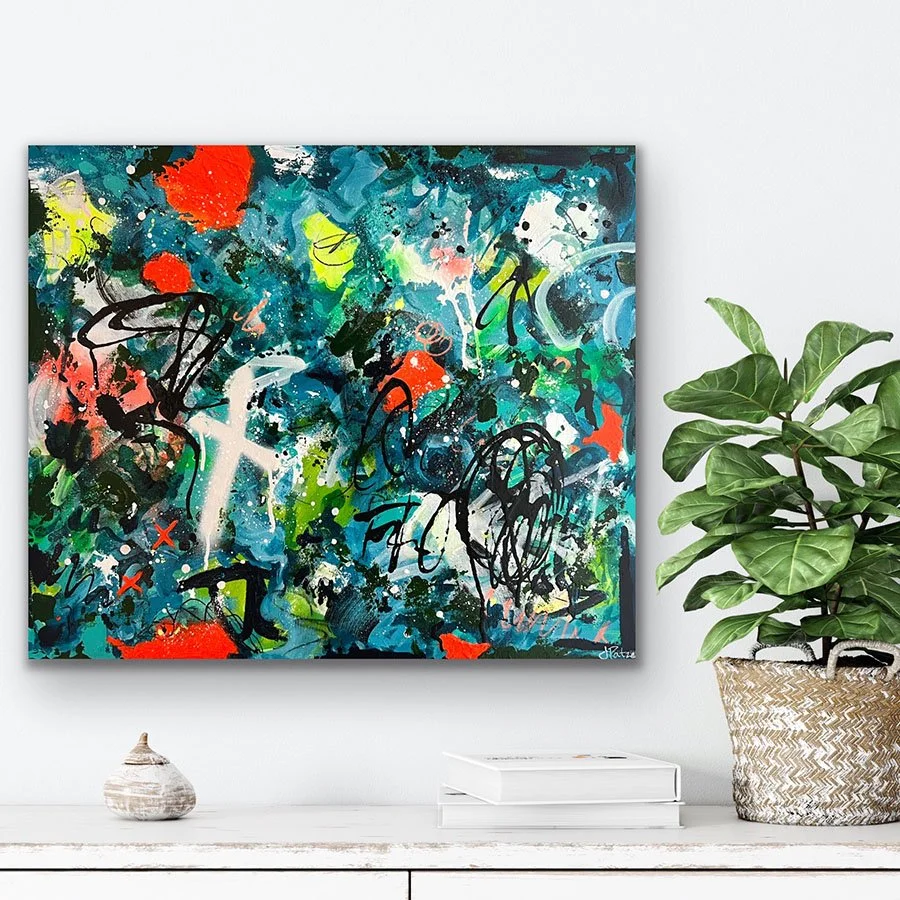 Street Level painting hanging on wall next plant.