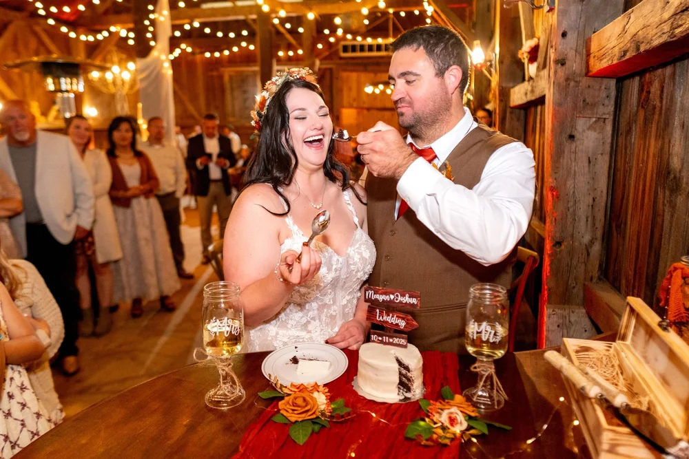 Meagan and Joshua cake cutting in barn reception at The Watson Homestead Hiram Maine fall wedding photography VMG Productions