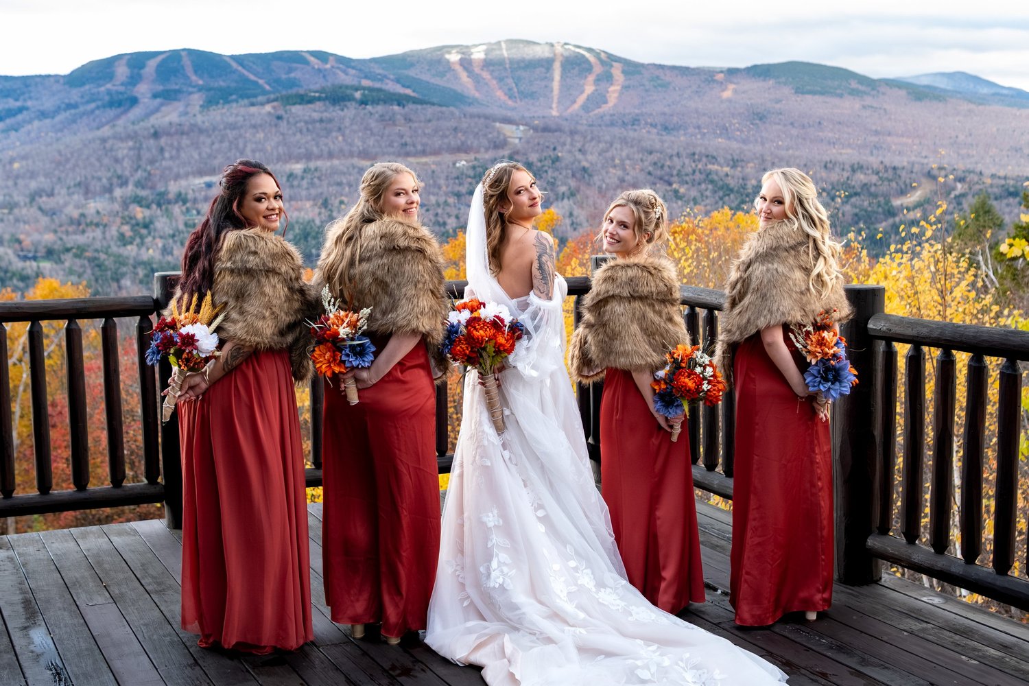Sarah bridesmaids red dresses fur shawls looking back over shoulder SkiEsta mountain view Newry Maine fall wedding VMG Productions
