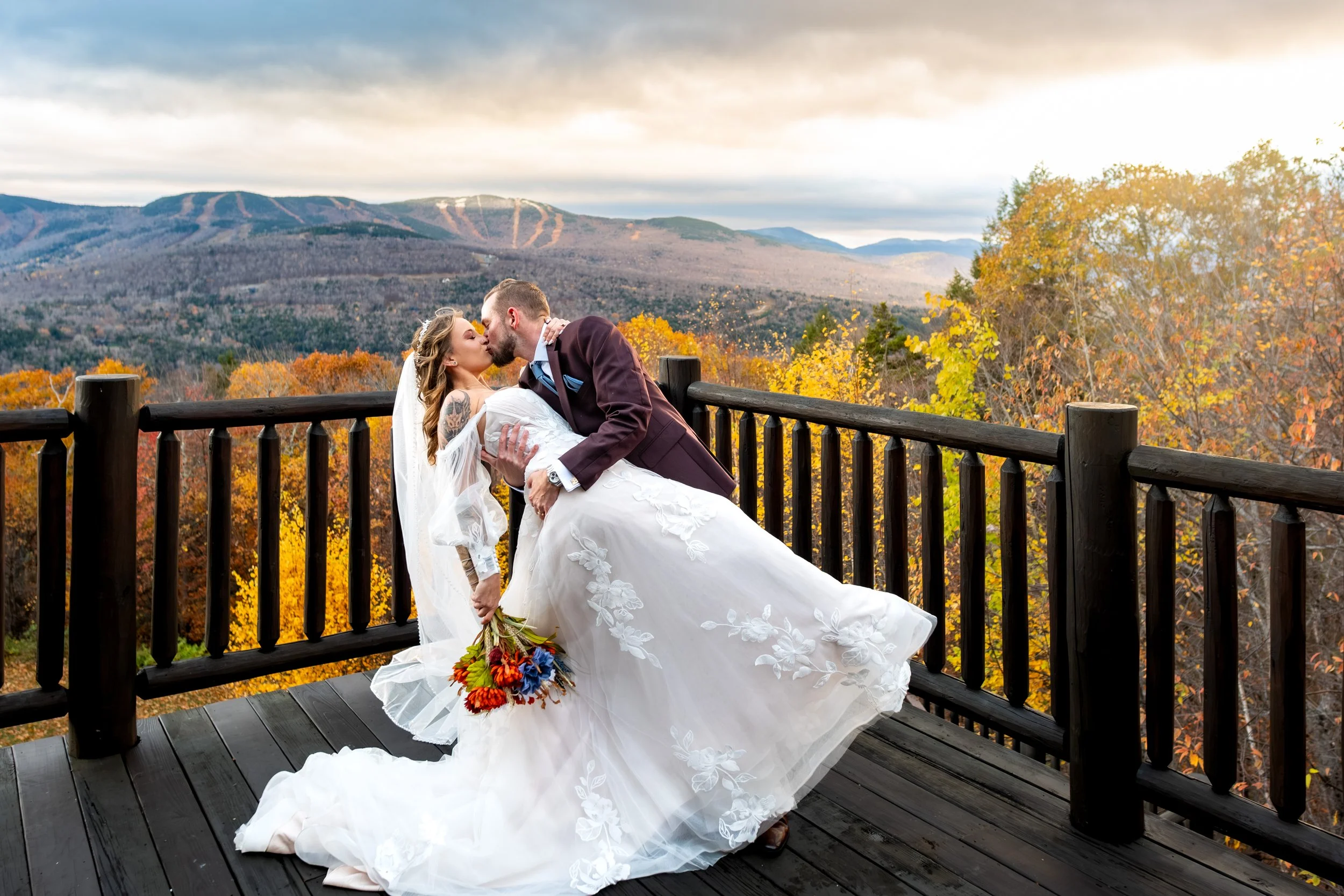 Sarah and Steve dip kiss portrait on SkiEsta deck fall mountain backdrop Newry Maine wedding photography VMG Productions