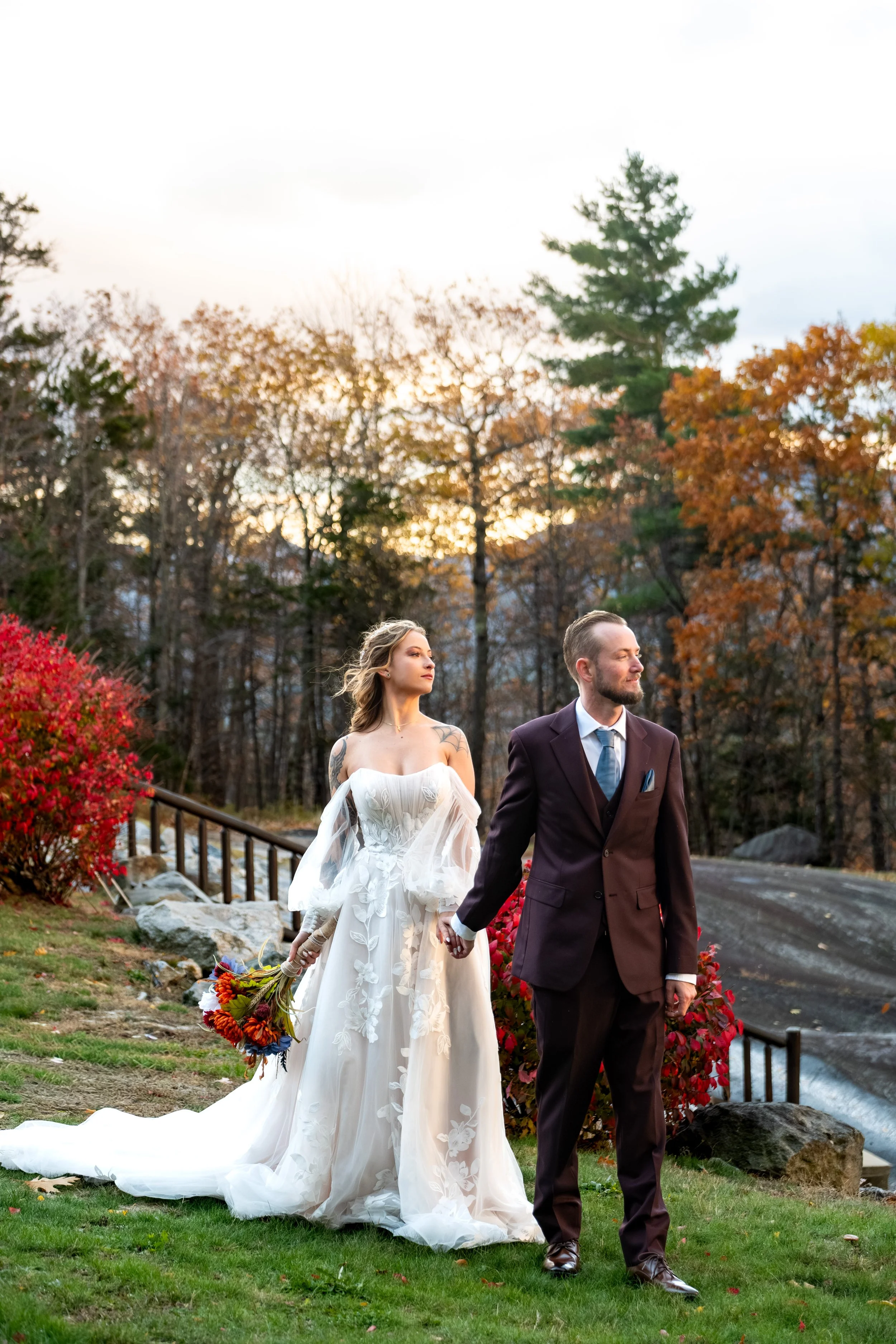 Sarah and Steve walking hand in hand SkiEsta grounds red foliage golden hour Newry Maine fall wedding portraits VMG Productions
