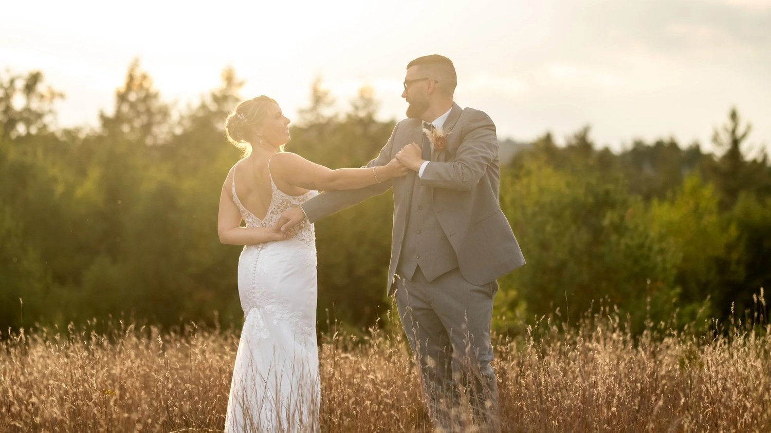Bride and groom dancing in a golden field at sunset, Leighton wedding, Maine