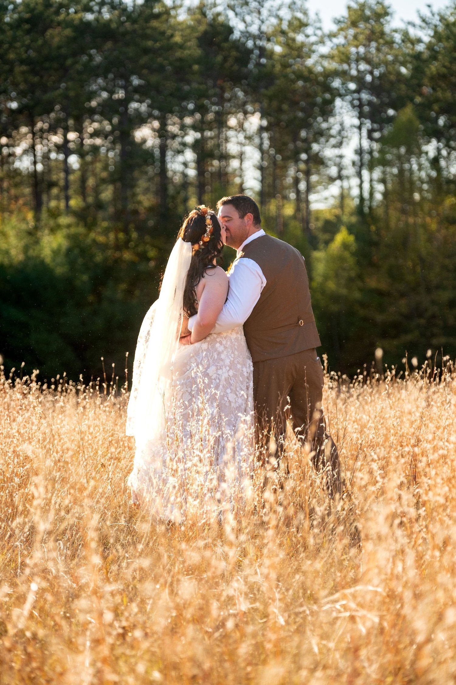 Meagan and Joshua kissing in golden field at The Watson Homestead Hiram Maine fall wedding photography VMG Productions