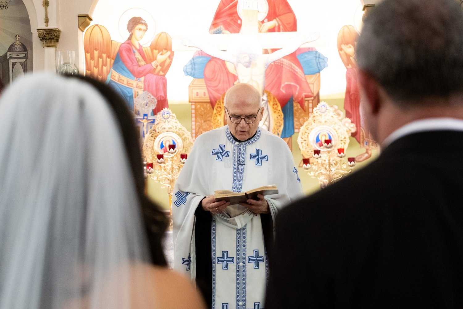 Nicole and Alexey sharing a smile at the altar at Holy Trinity Greek Orthodox Church Portland Maine summer wedding photography VMG Productions
