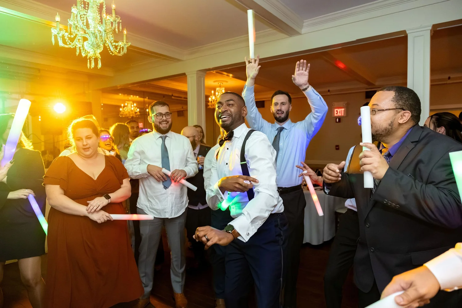 Groom dancing with guests holding glow sticks at a Kennebunkport Maine wedding reception