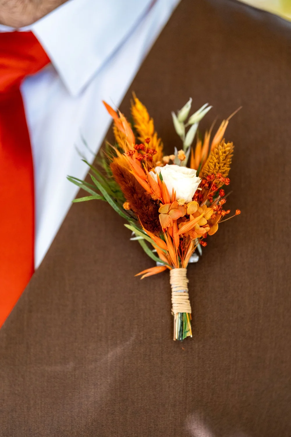 Joshua boutonniere with fall florals and burnt orange tie at The Watson Homestead Hiram Maine fall wedding photography VMG Productions