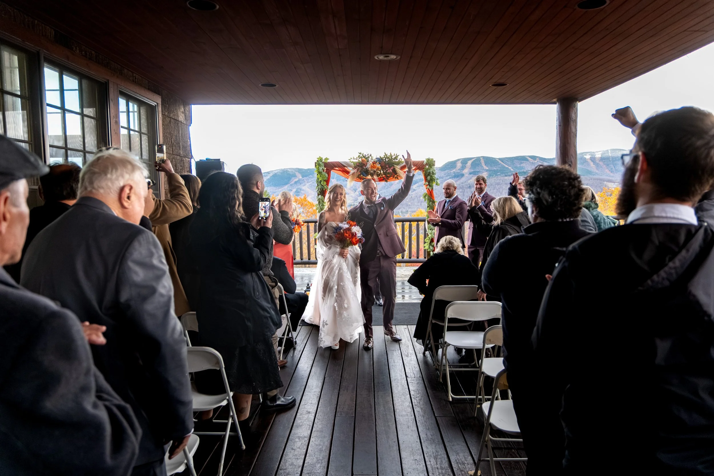Sarah and Steve recessional arm raised just married SkiEsta pavilion fall mountain backdrop Newry Maine wedding VMG Productions