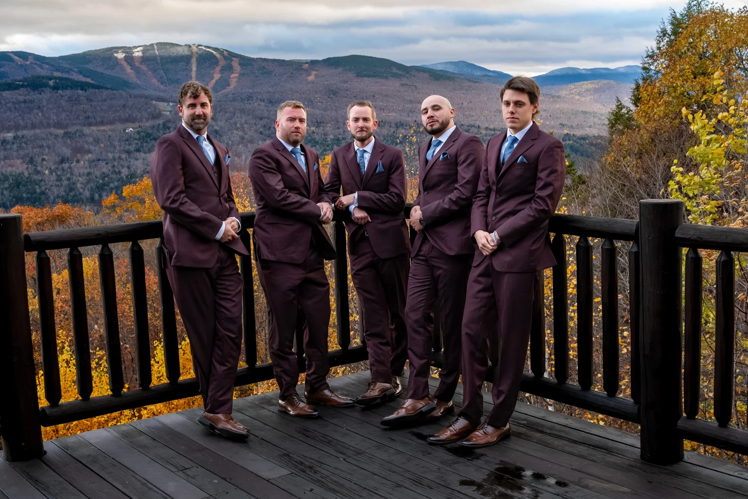 Steve groomsmen burgundy suits standing on SkiEsta deck fall mountain backdrop Newry Maine wedding VMG Productions