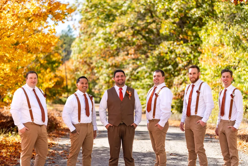 Joshua and groomsmen standing in fall foliage at The Watson Homestead Hiram Maine fall wedding photography VMG Productions