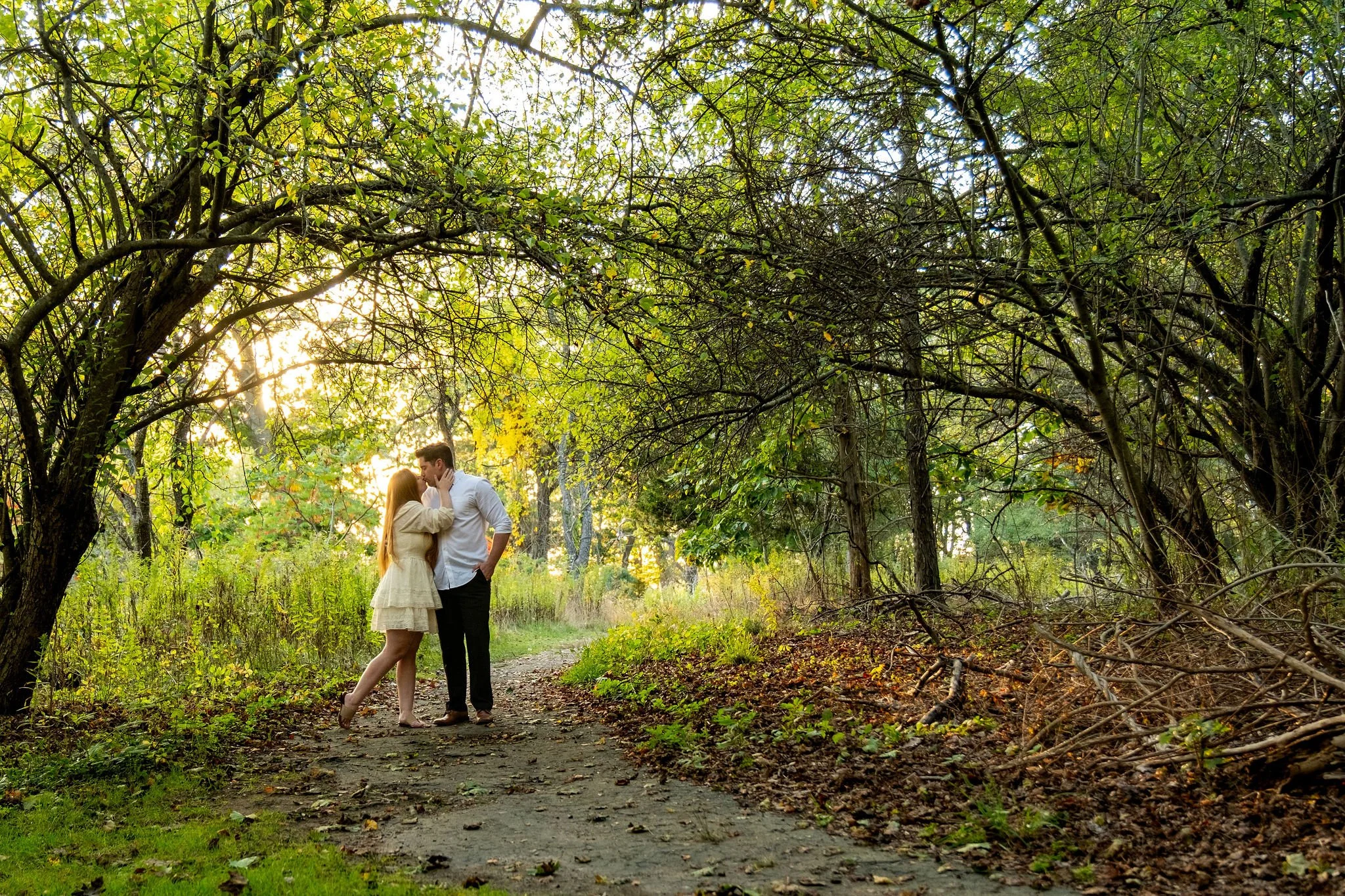 Kayla and Ethan engaged couple walking under tree canopy path Odiorne Point State Park Rye New Hampshire engagement photography VMG Productions
