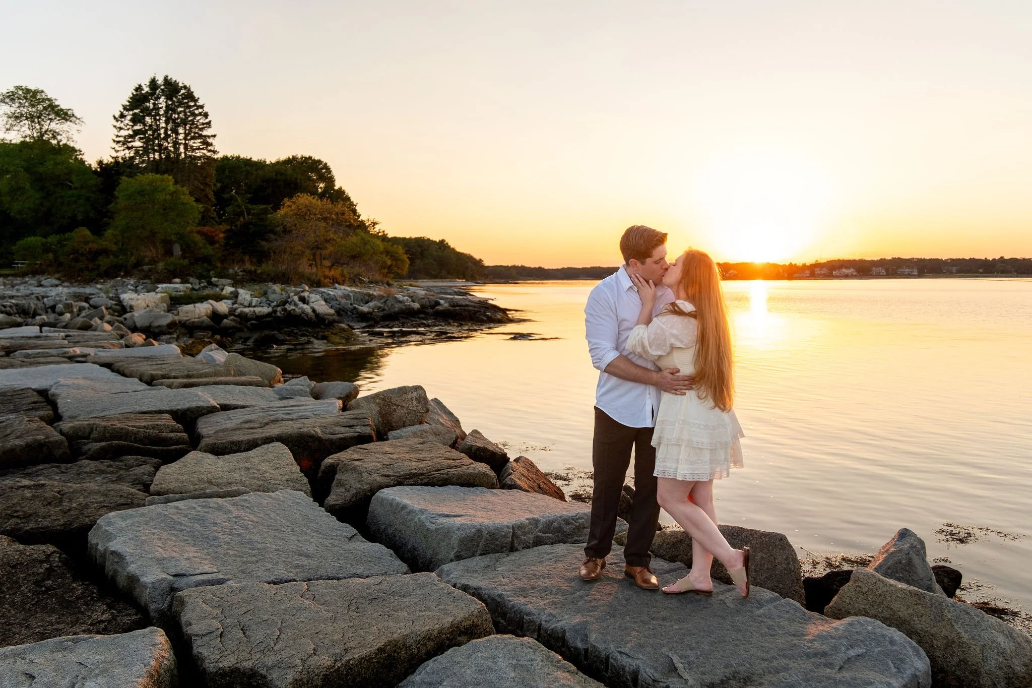 Kayla and Ethan engaged couple kissing rocky shoreline sunset Odiorne Point State Park New Hampshire engagement photography VMG Productions