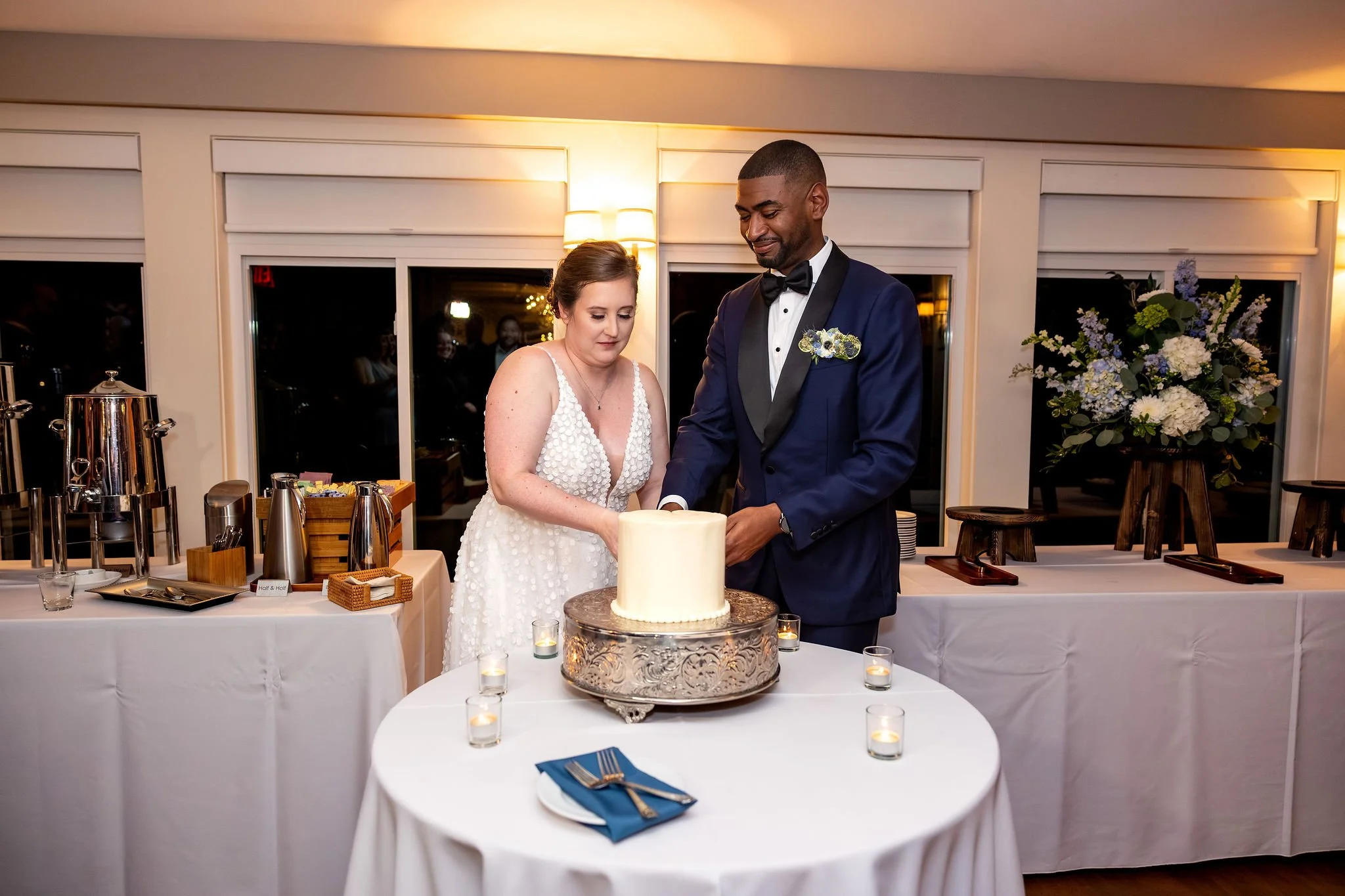 Kaitlyn and Darren cutting wedding cake together at reception Nonantum Resort Kennebunkport Maine fall wedding photography VMG Productions