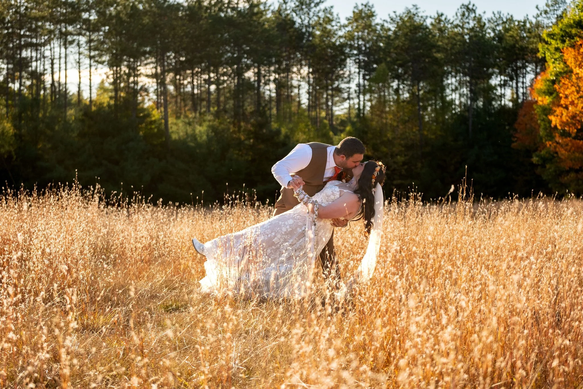 Meagan and Joshua dip kiss in golden field at The Watson Homestead Hiram Maine fall wedding photography VMG Productions
