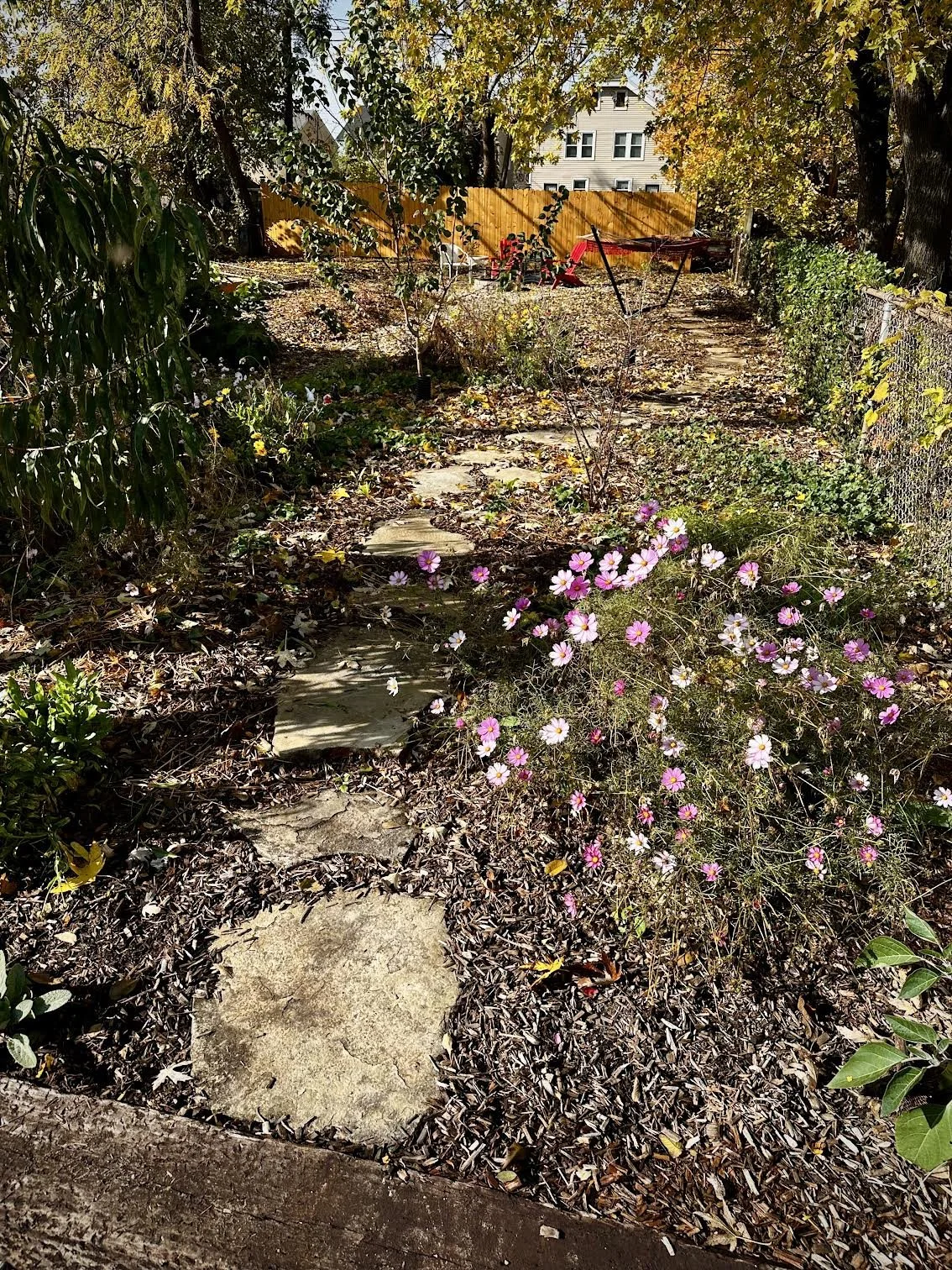 A path amidst wildflowers and stone fruit trees (cherry, peach, apricot, and plum) leads to a hammock next to the fire circle.