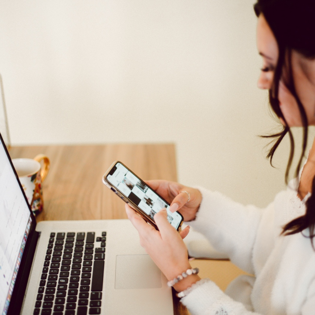 Ashley at computer with iphone