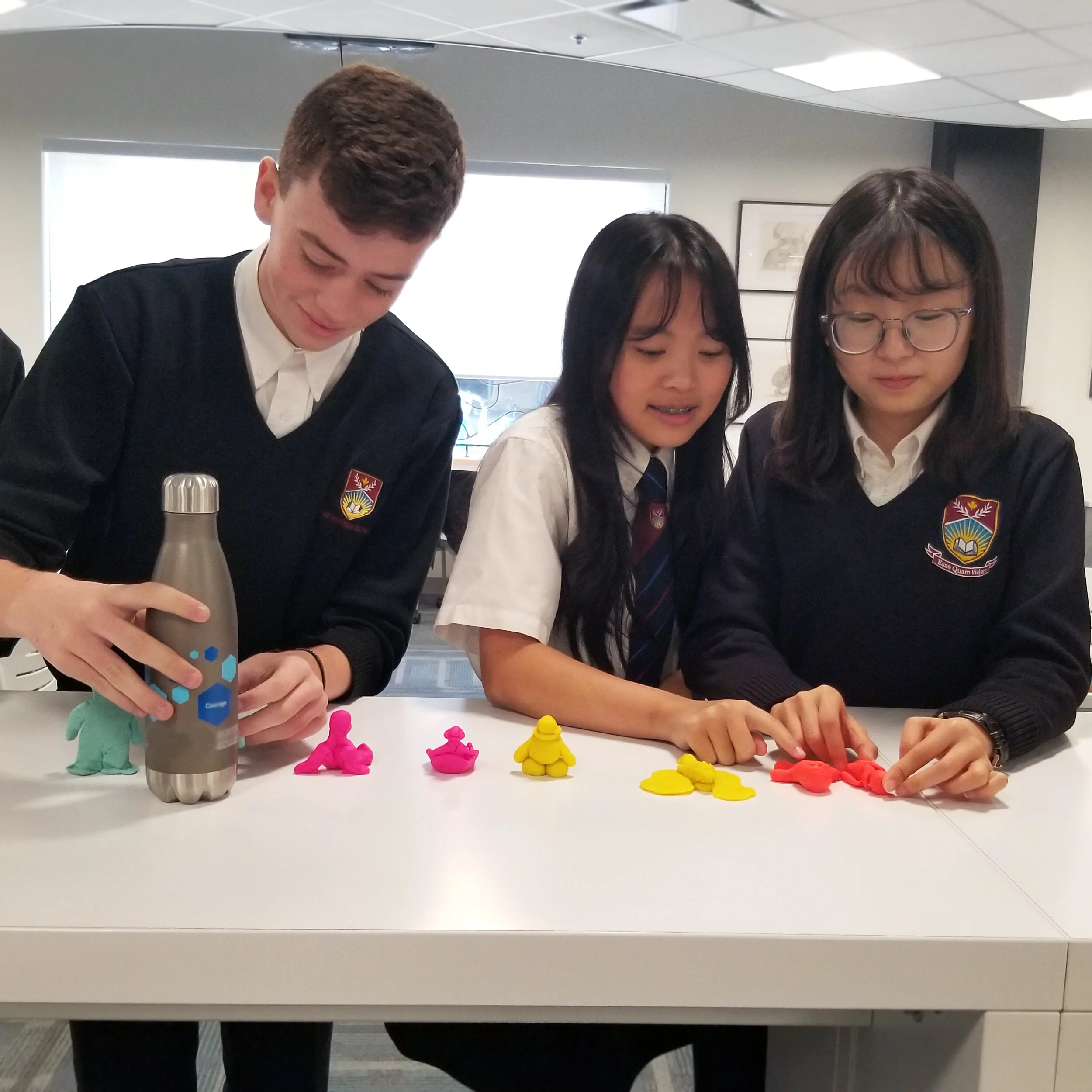 Students are learning about the philosophy of Plato through the creation of human figures made from Play-Doh.