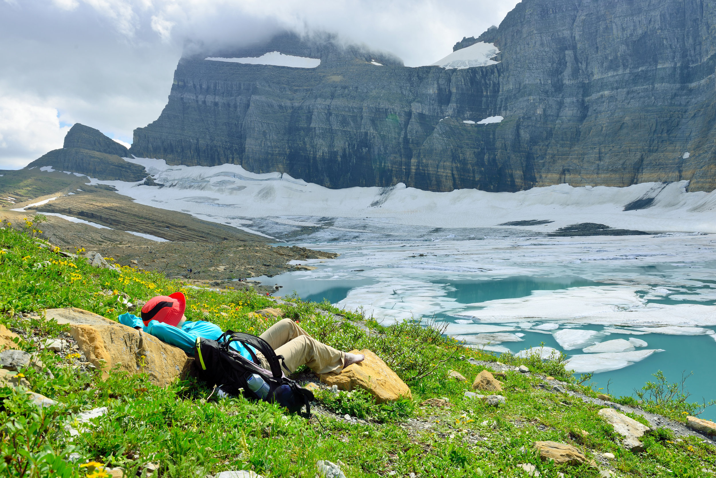 PICTURED: female hiker resting by the Grinnell glacier in Many Glaciers, Glacier National Park, Montana in summer. North American glaciers are the most at risk, the study suggests.