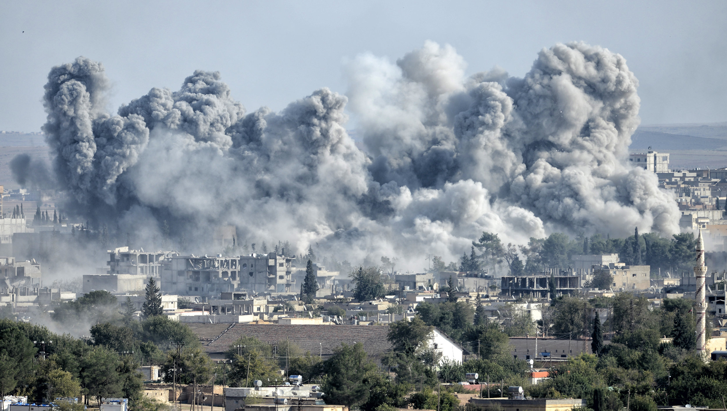PICTURED: An explosion after an apparent US-led coalition airstrike on Kobane, Syria, as seen from the Turkish side of the border. Credit Orlok.