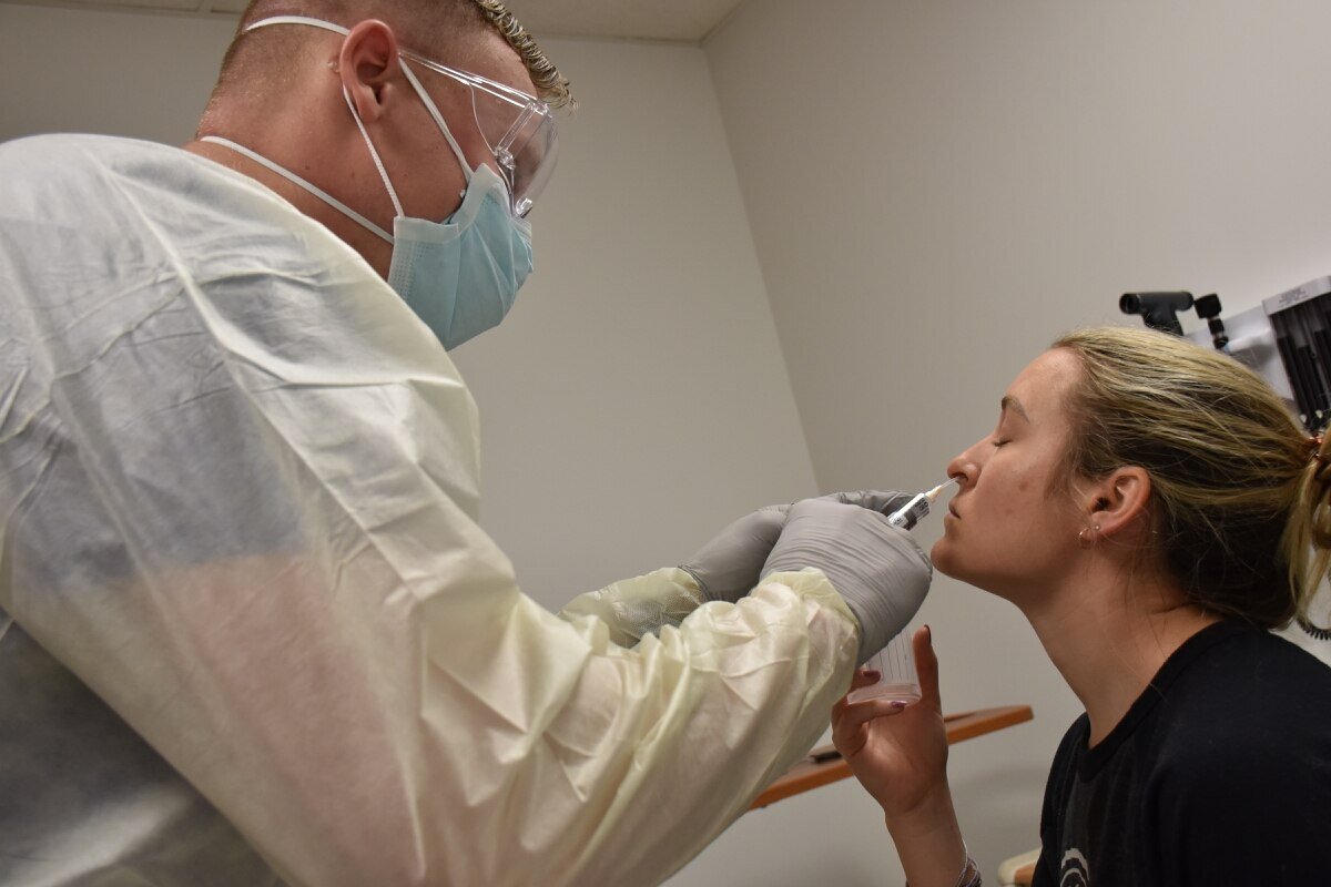 March 26th, 2020. PICTURED: Pfc. Casey Tebo, a medic in the Womack Urgent Care, performs a COVID-19 test on a patient. Photo credit: Twana Atkinso, Army.