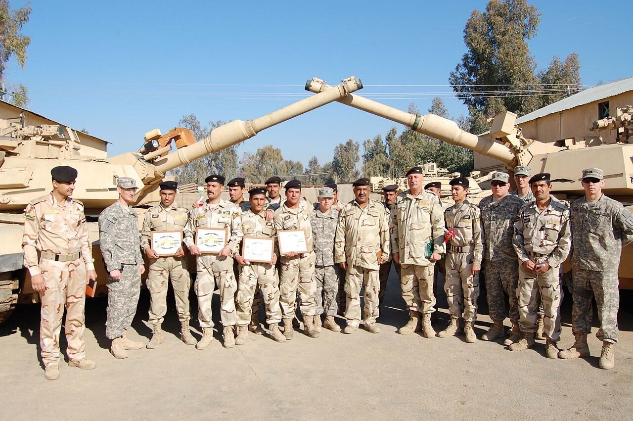 IRAQ, January 20th, 2011. PICTURED: Soldiers with the 2nd Advise and Assist Brigade, stand with the graduating Iraqi tank class at Camp Taji, Iraq, where training the ISF has gone on for a decade or more.