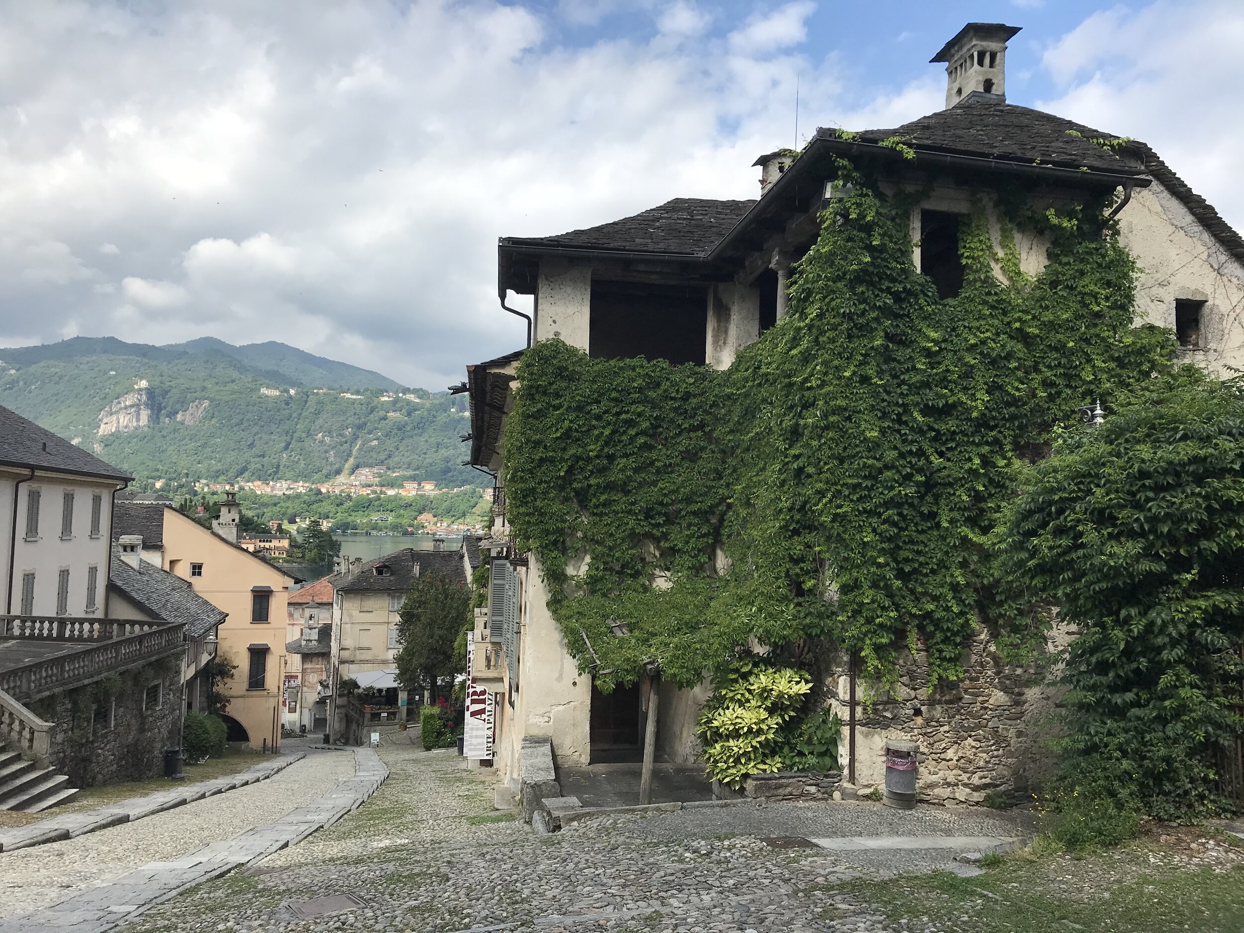 ORTA, Piedmont, Italy. September 10th, 2020. PICTURED: A still-inhabited building from the 19th century, lining a road from the church to Piazza Motta, enjoys a blanket of wisteria vine over its stone and wooden facade.