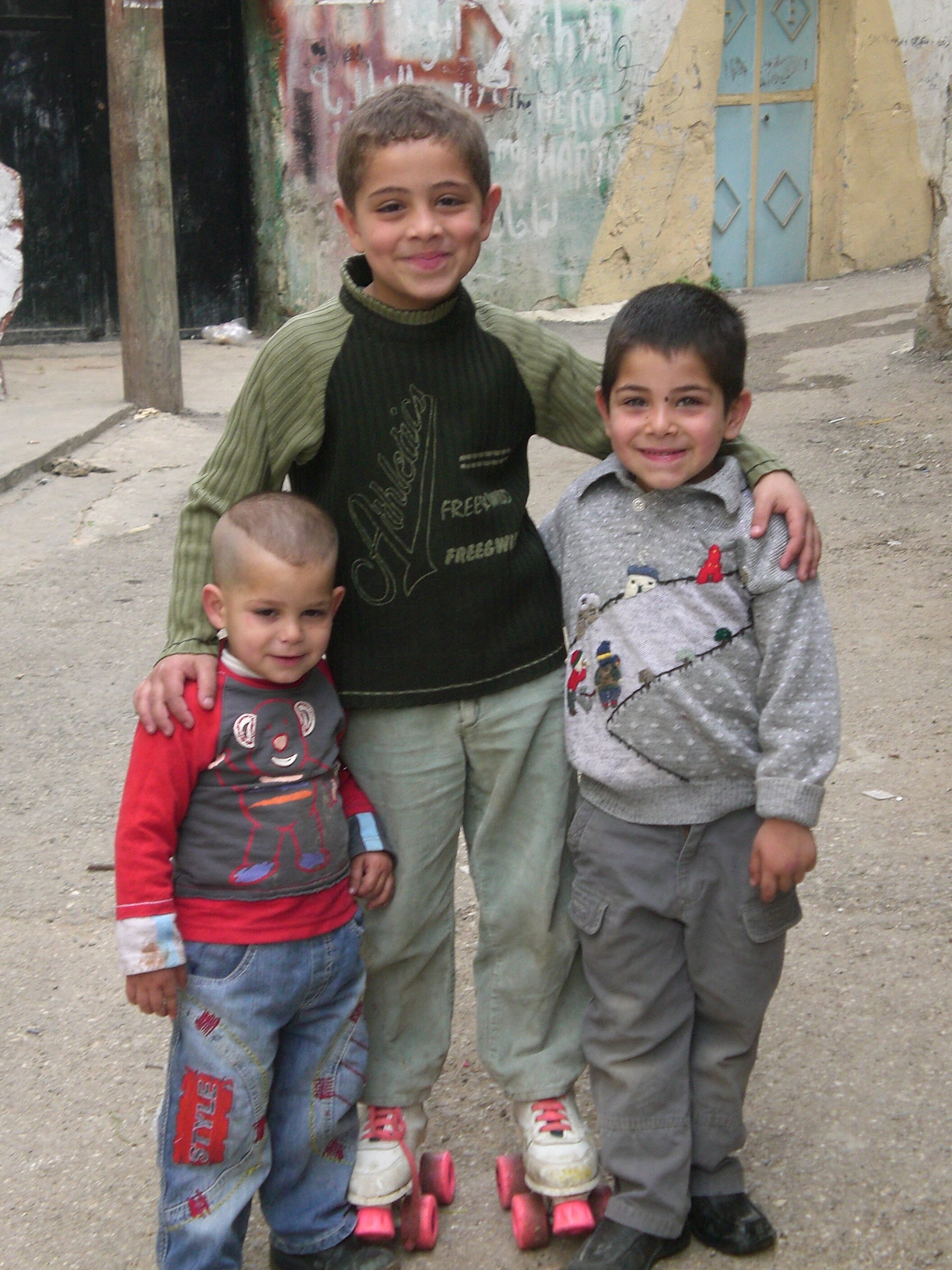   DAMASCUS, Syria. October 2007. PICTURED:  Tartus’ three sons smile for the camera while playing on the street. 