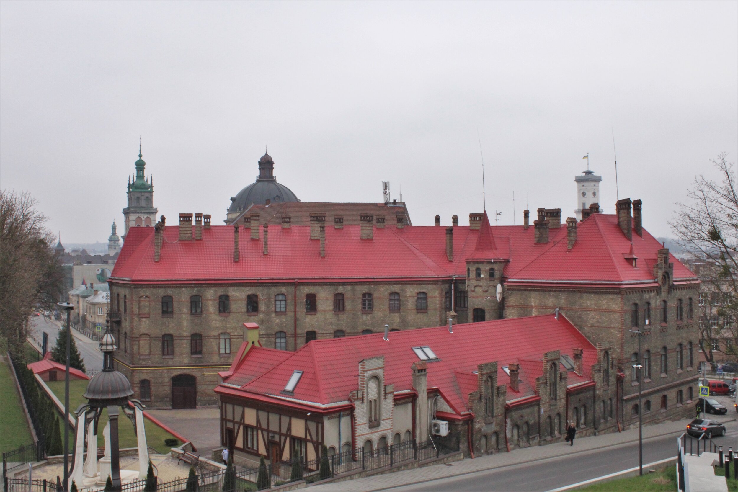   L’VIV, Ukraine. April 2021 PICTURED:  The stately red and brick facades of nothing less than the central fire station, with the three tallest church towers rise just behind. 