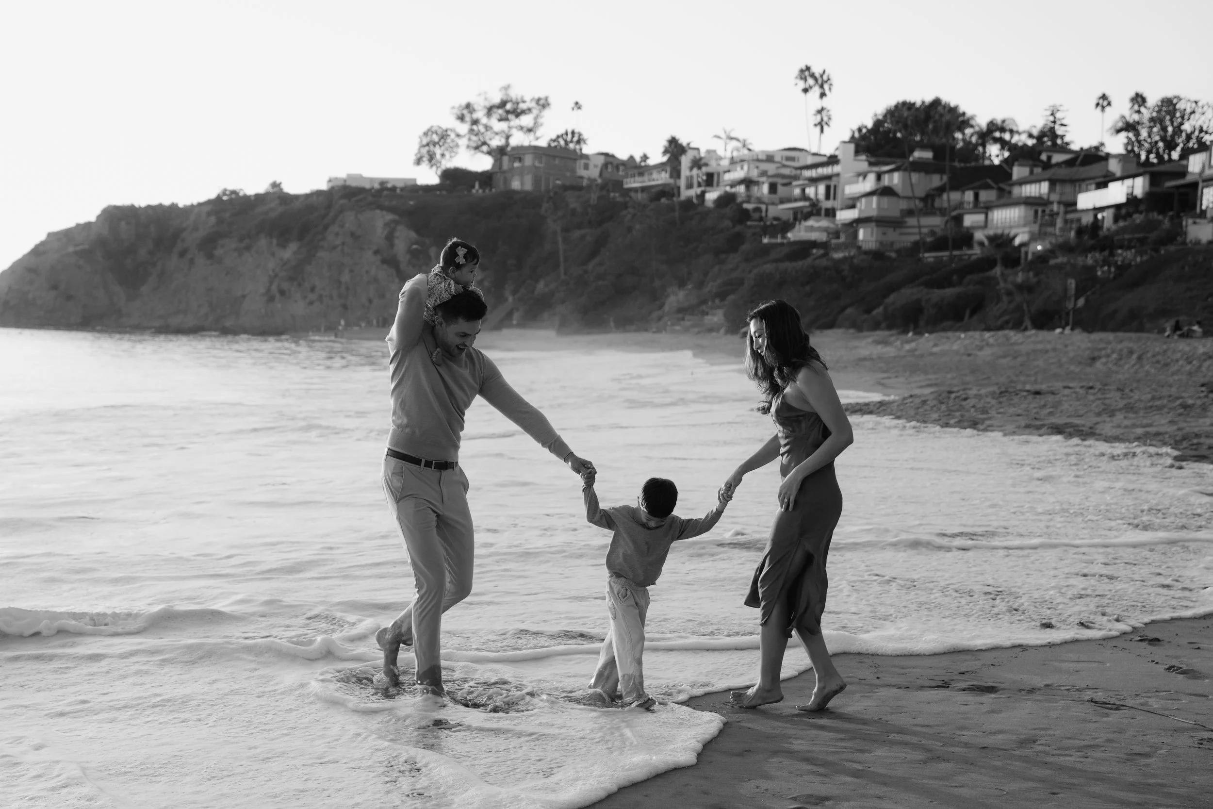 Family walking along the shoreline during a Laguna Beach photo session.