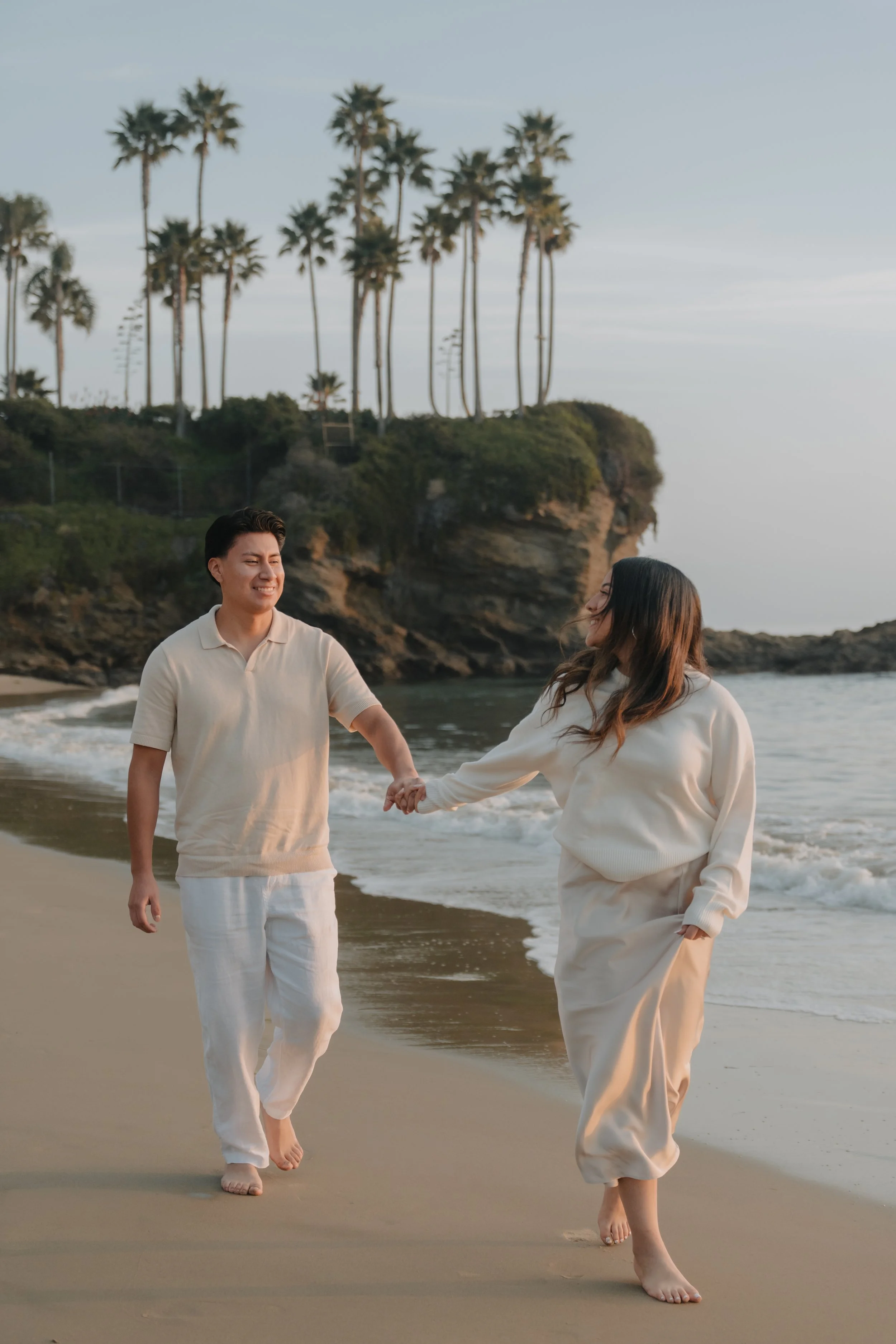 Couple walking along the shoreline during a Laguna Beach photo session.