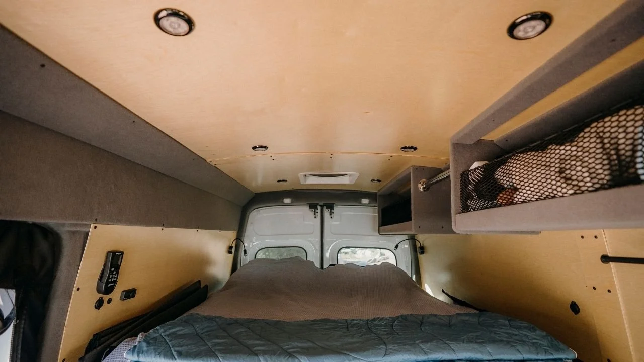 inside the back of Adventure Van is a fully made bed with memory foam mattress and pillows