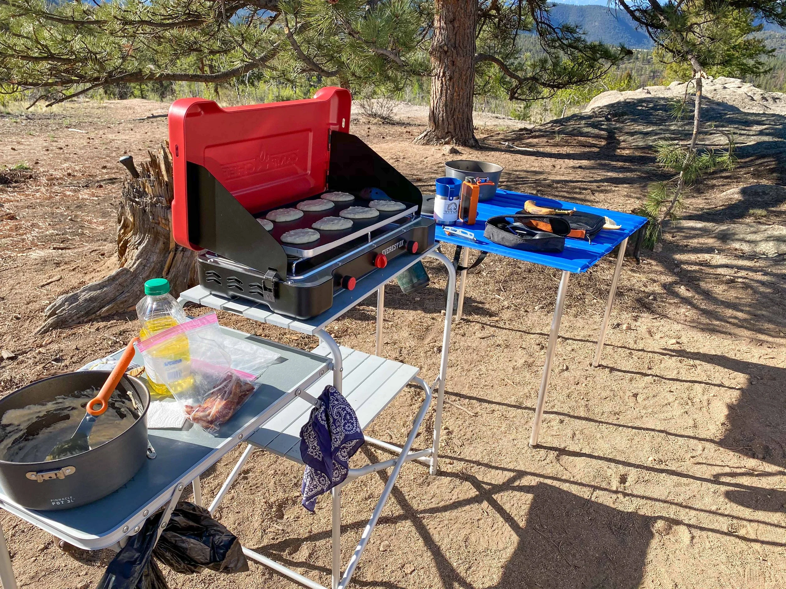 Picture of camp kitchen set-up, cooking pancakes on the griddle. From Titus Adventure Company  4WD & camping rentals
