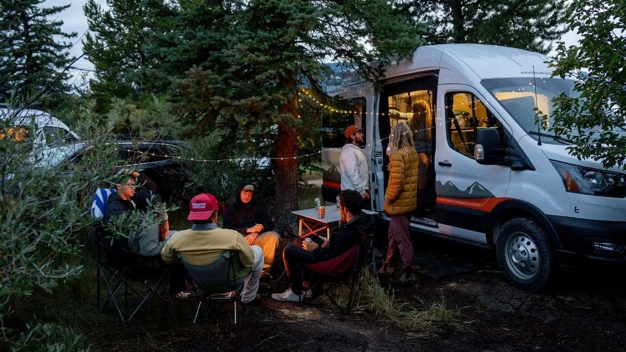 friends enjoy a campfire beside Emmylou the Adventure Van from Titus Adventures