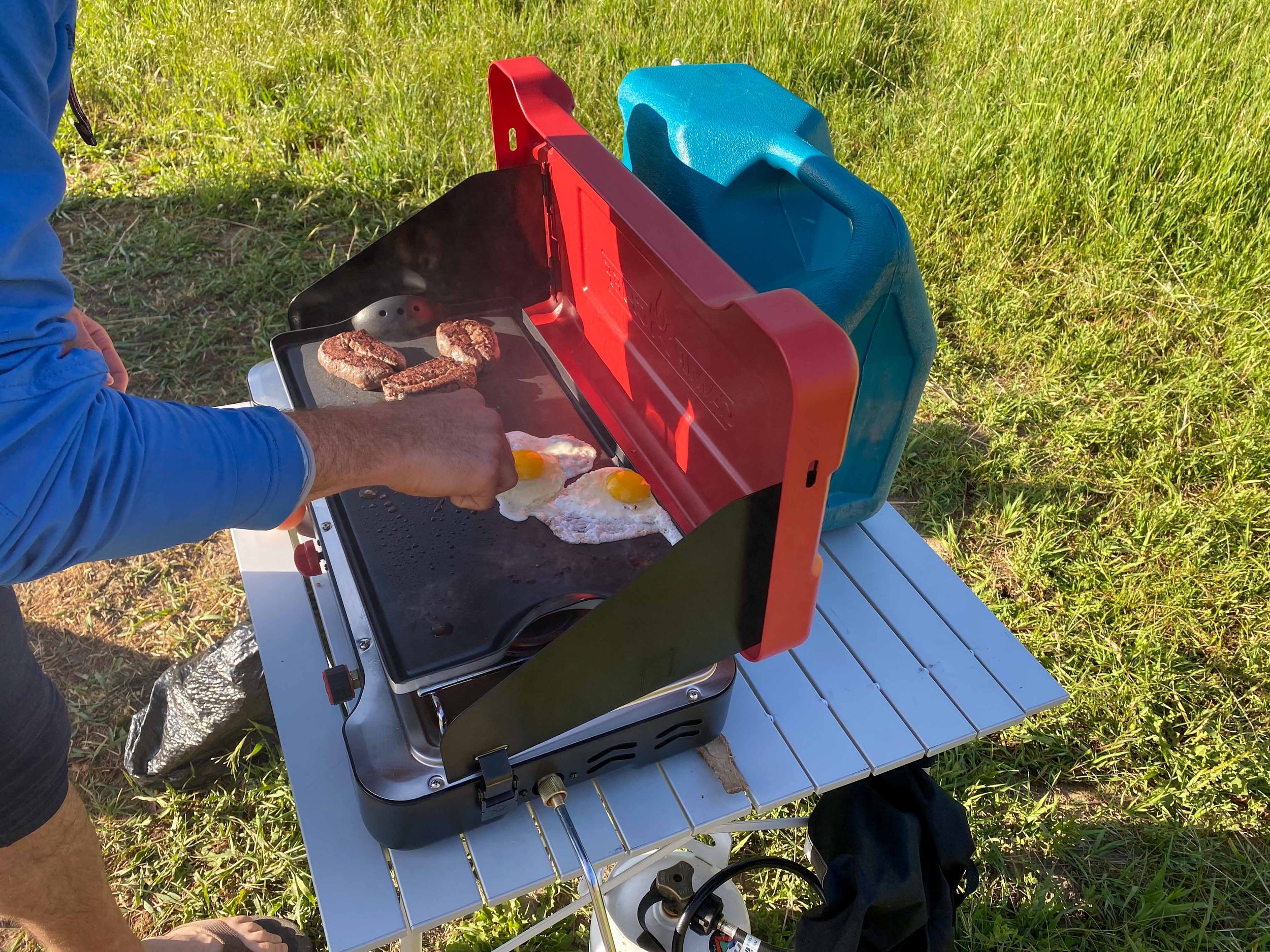 Titus Adventure Company, Denver, CO camping rentals, making steak and eggs on the camp stove.
