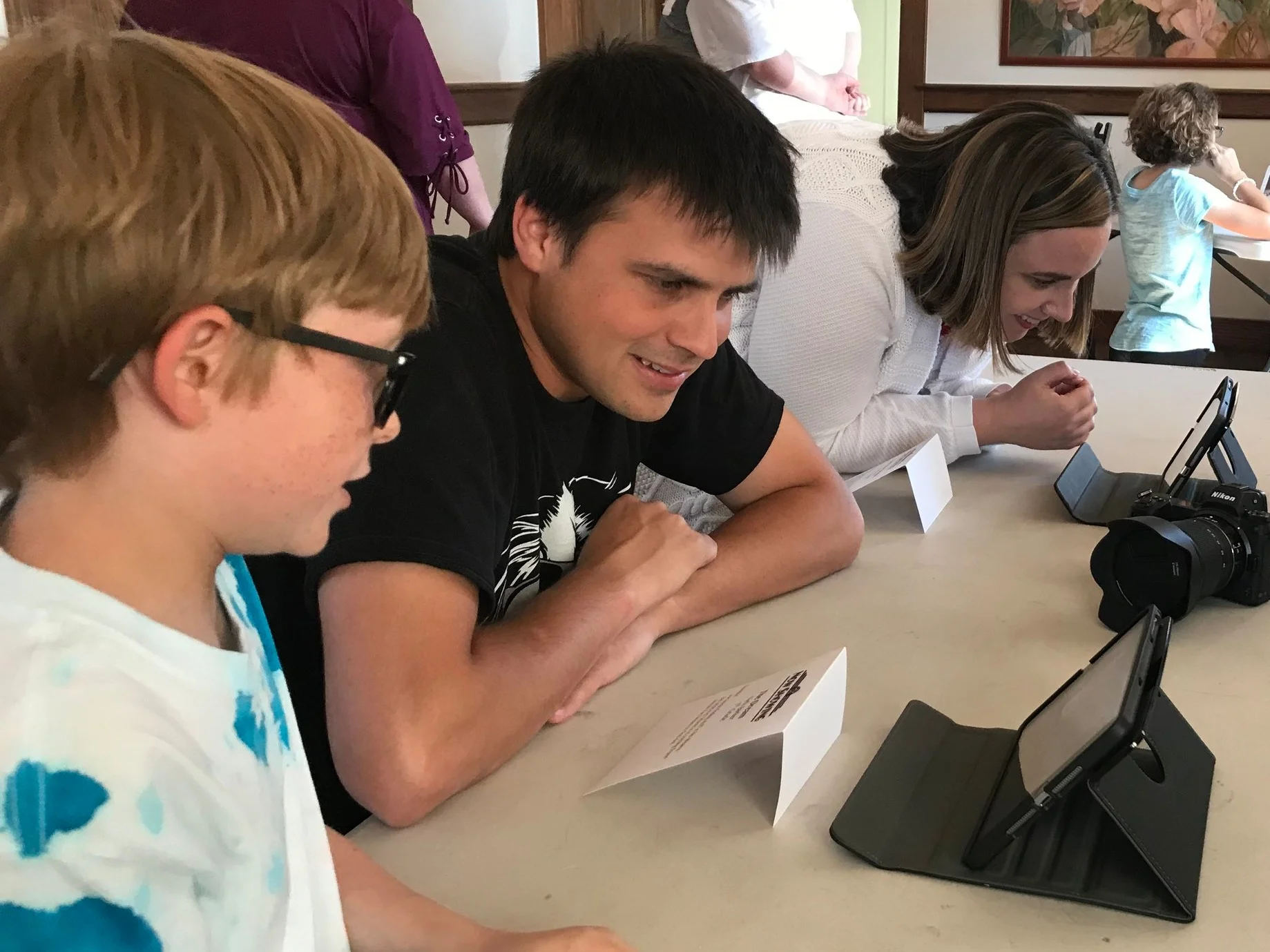 A camper proudly showing his final project to Matt.