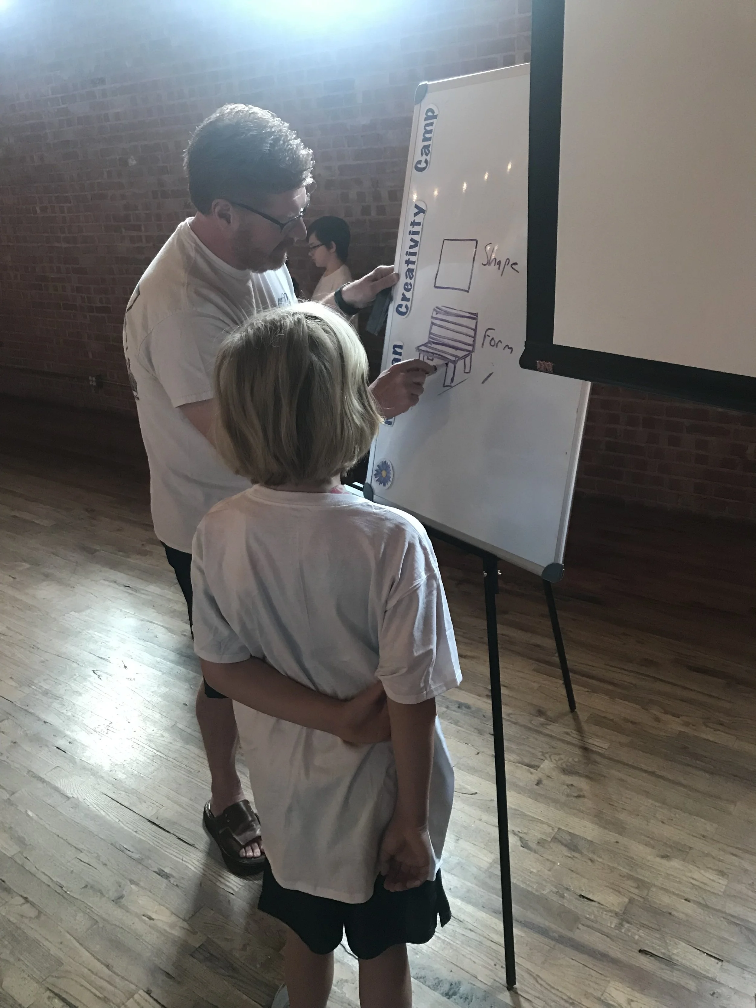 Don works with a camper to help bring his painting to life.