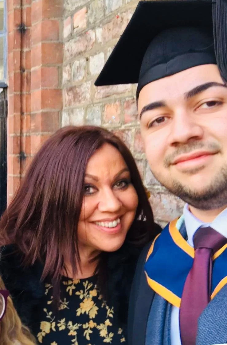 Mother and son posing for a celebratory photo of a graduation