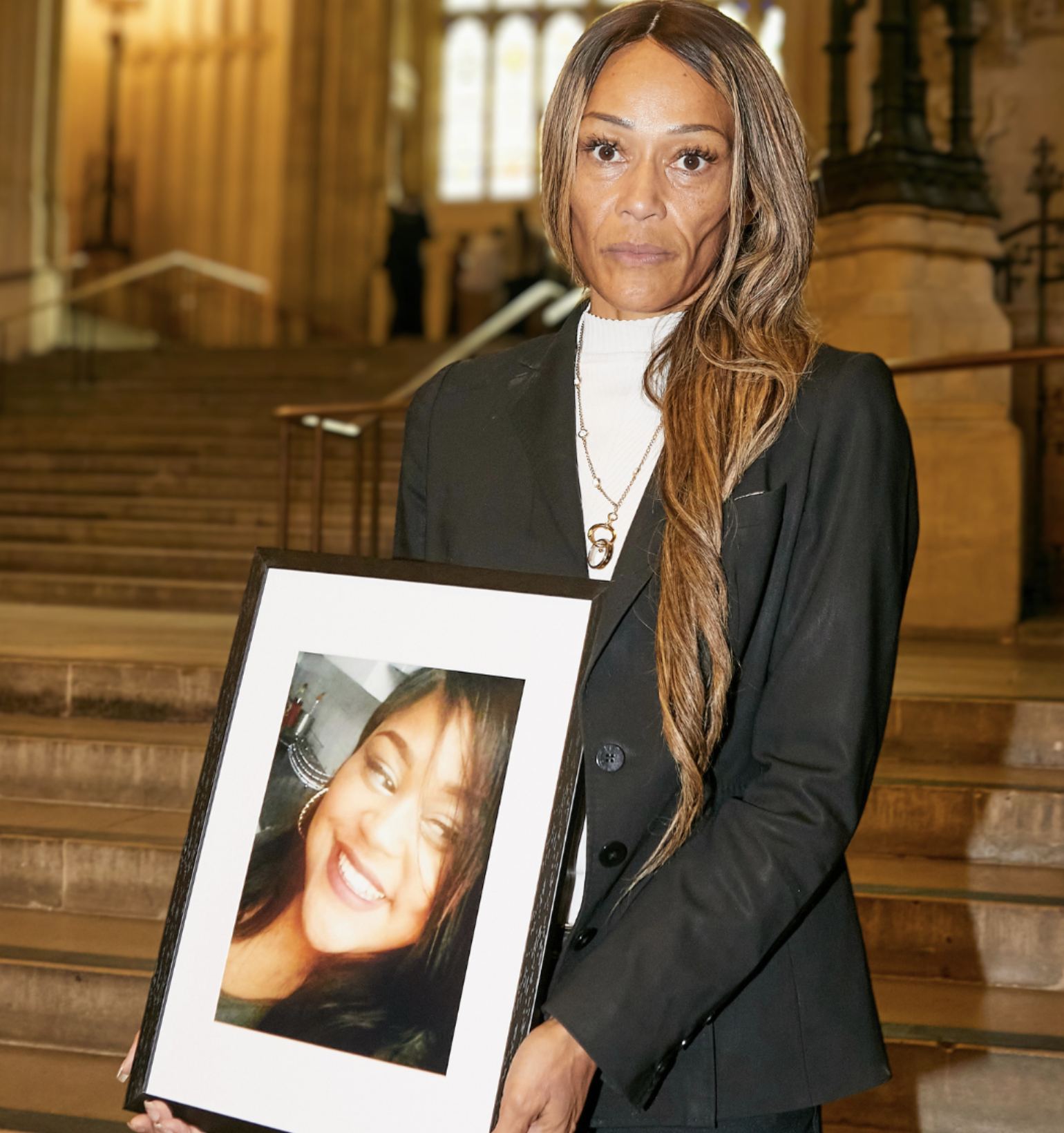 Emma, holding a photograph of her daughter Shanté who died from anaphylaxis