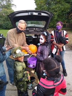Kelly Green volunteers distributing pumpkins to children