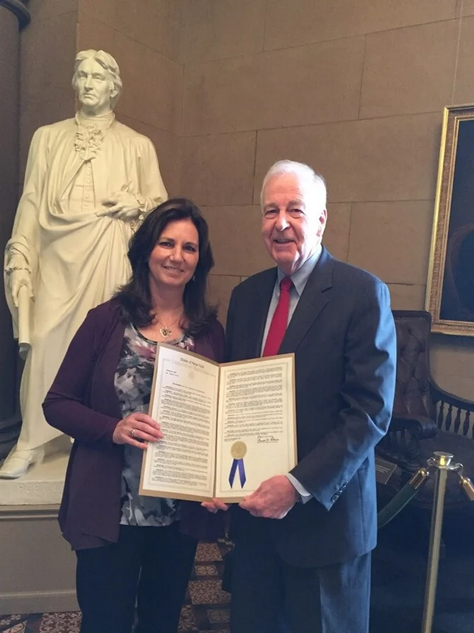 Patti Wukovits and Senator Kemp Hannon of Long Island, NY holding the MenB Awareness Month resolution on June 2018.