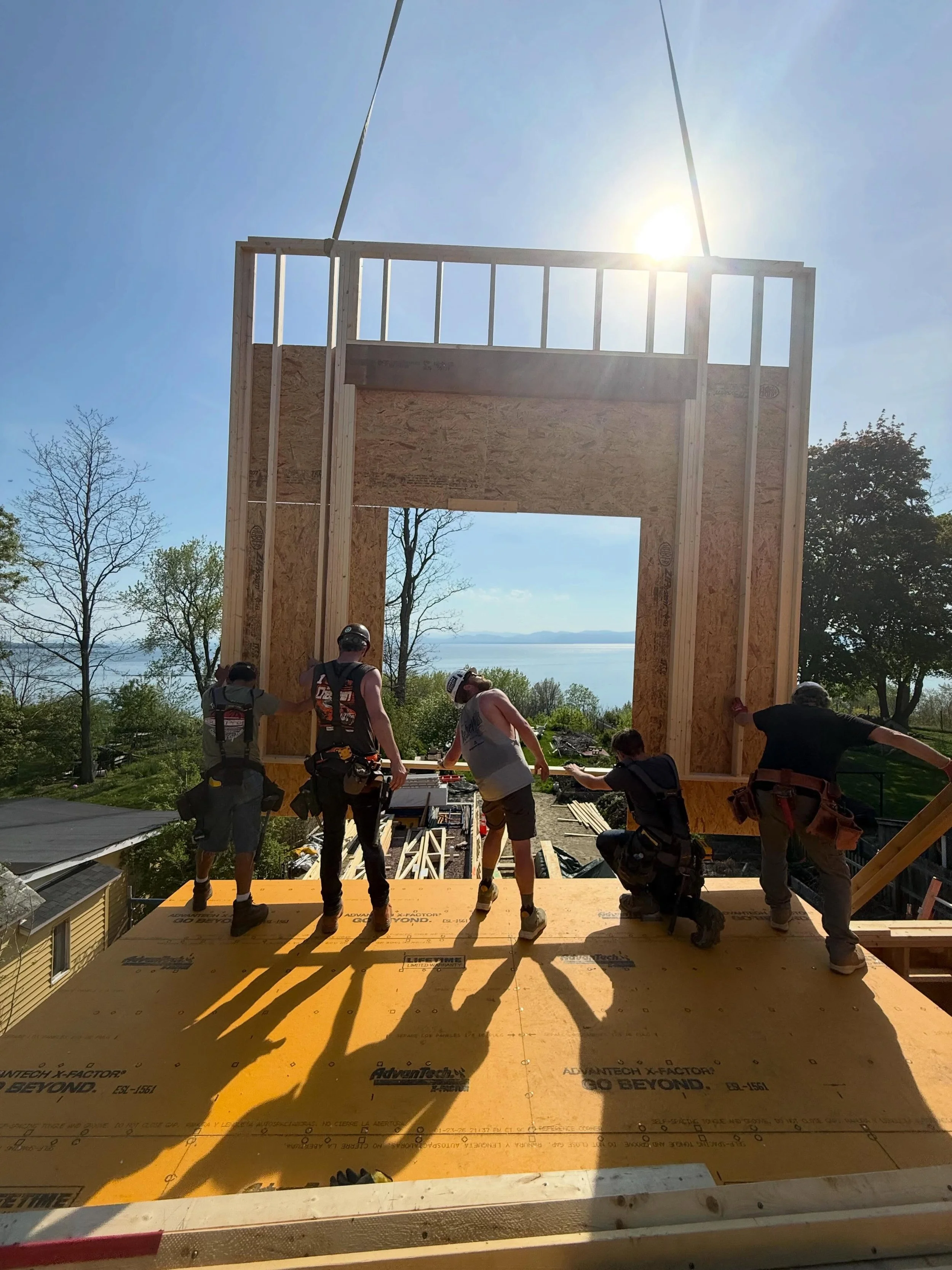 Happy Friday everyone!  We had an exciting and productive week at our lakeview project.  With the assistance of a crane we set all exterior wall panels to the second story of our addition project and roof trusses in three days.  The weather was beaut