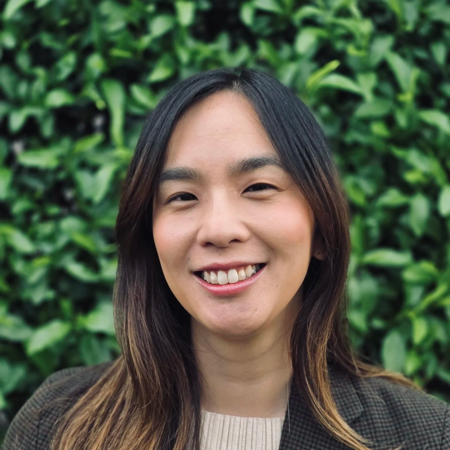 Young woman smiling in a cornfield.