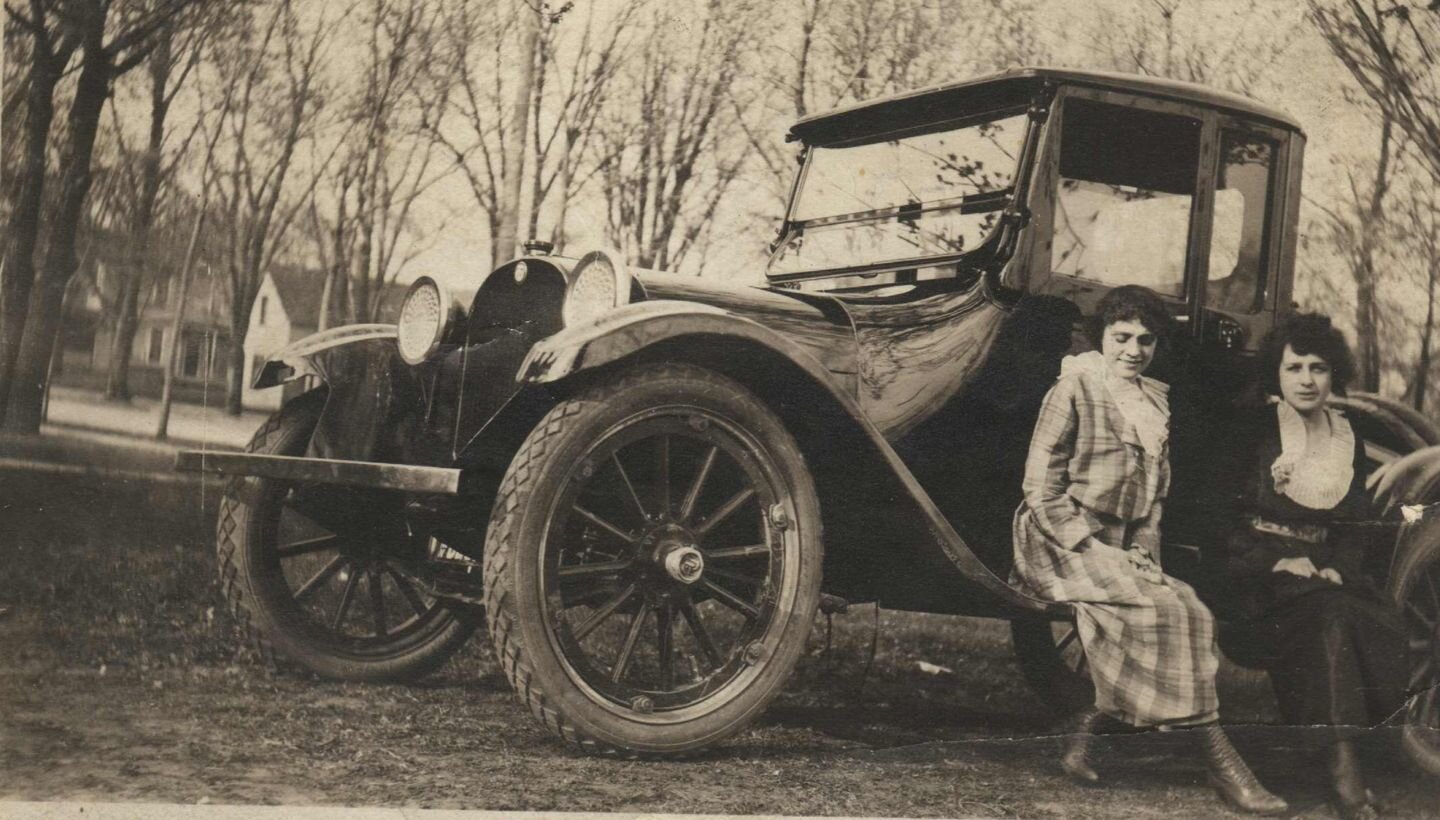 Mrs. A.H. Smith &amp; Mrs. Chase on the running board of Mrs. Chase's car. Back of photograph handwritten in pencil &quot;4 cylander Dodge purchased 1919 came with out top, two extra tires, cost $1600.00. Bought at Main Motor Sales. Present to Mrs. R