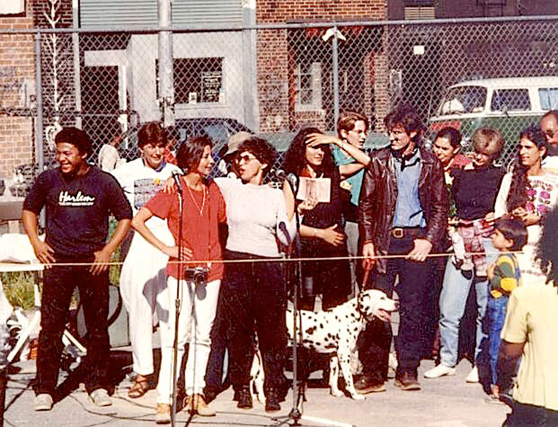 La Lucha muralists. From left: Pat Brazill, Noah Jemisin, Nancy Sullivan, Cliff Joseph, Camille Perrottet, Maria Dominguez, Chico, Eva Cockcroft speaking, Karin Batten, Willie Birch (?), Rikki Asher, Keith Christensen, Susan Ackoff Ortega, Kristin Reed, Joe Stephenson, Seth Tobocman, Dina Bursztyn Photo © John Hunt