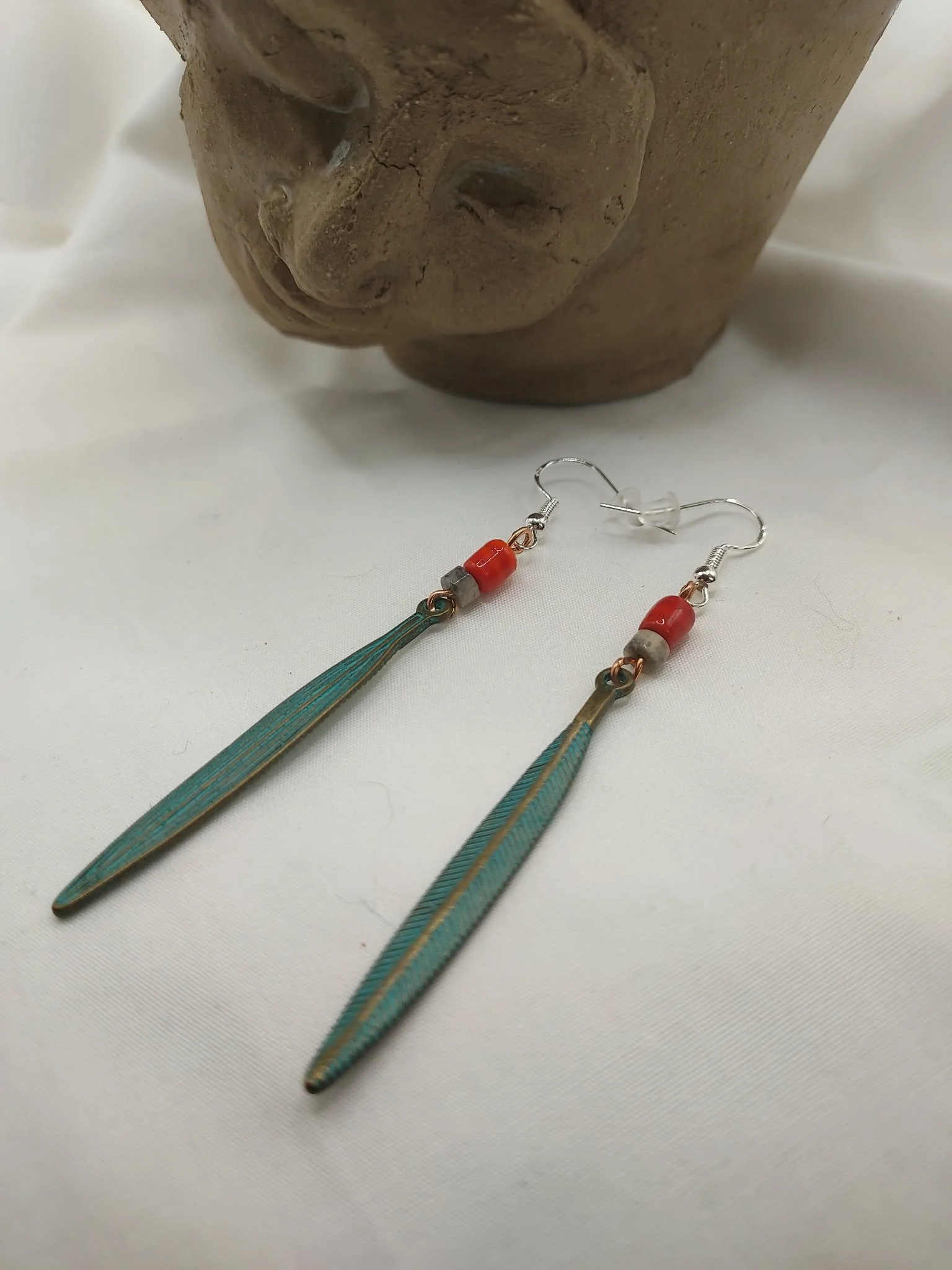 Long feather earrings with ceramic beads, 3" in length.