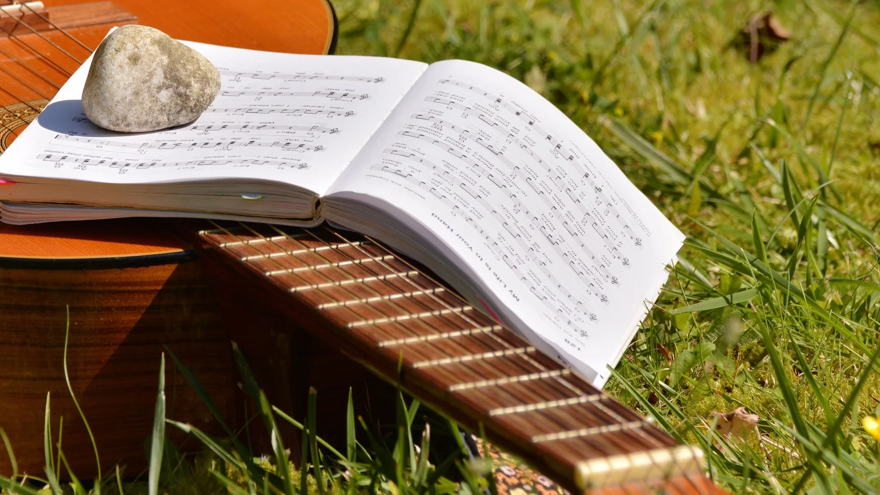 Canva+-+Song+Book+on+Brown+Classical+Guitar+on+Green+Grass+during+Daytime.jpg