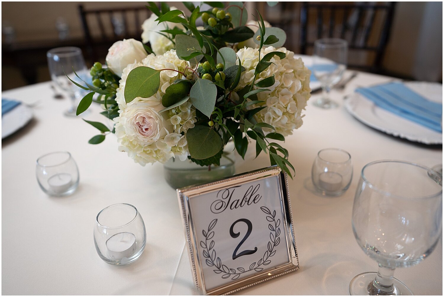  Table sign and white floral centerpiece 
