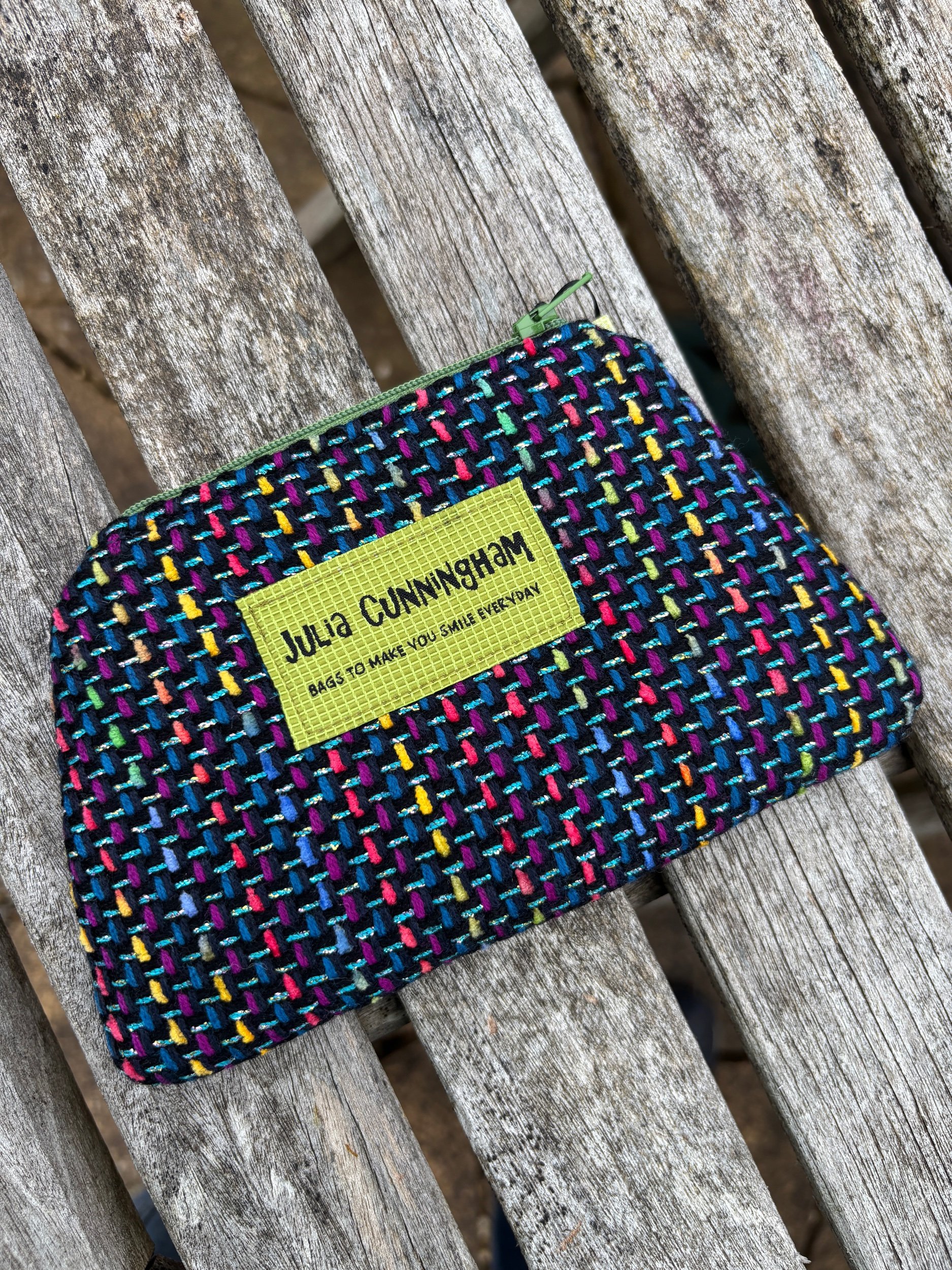 Front view of a handmade Scottish tweed zip pouch in bright, colourful tweed fabric