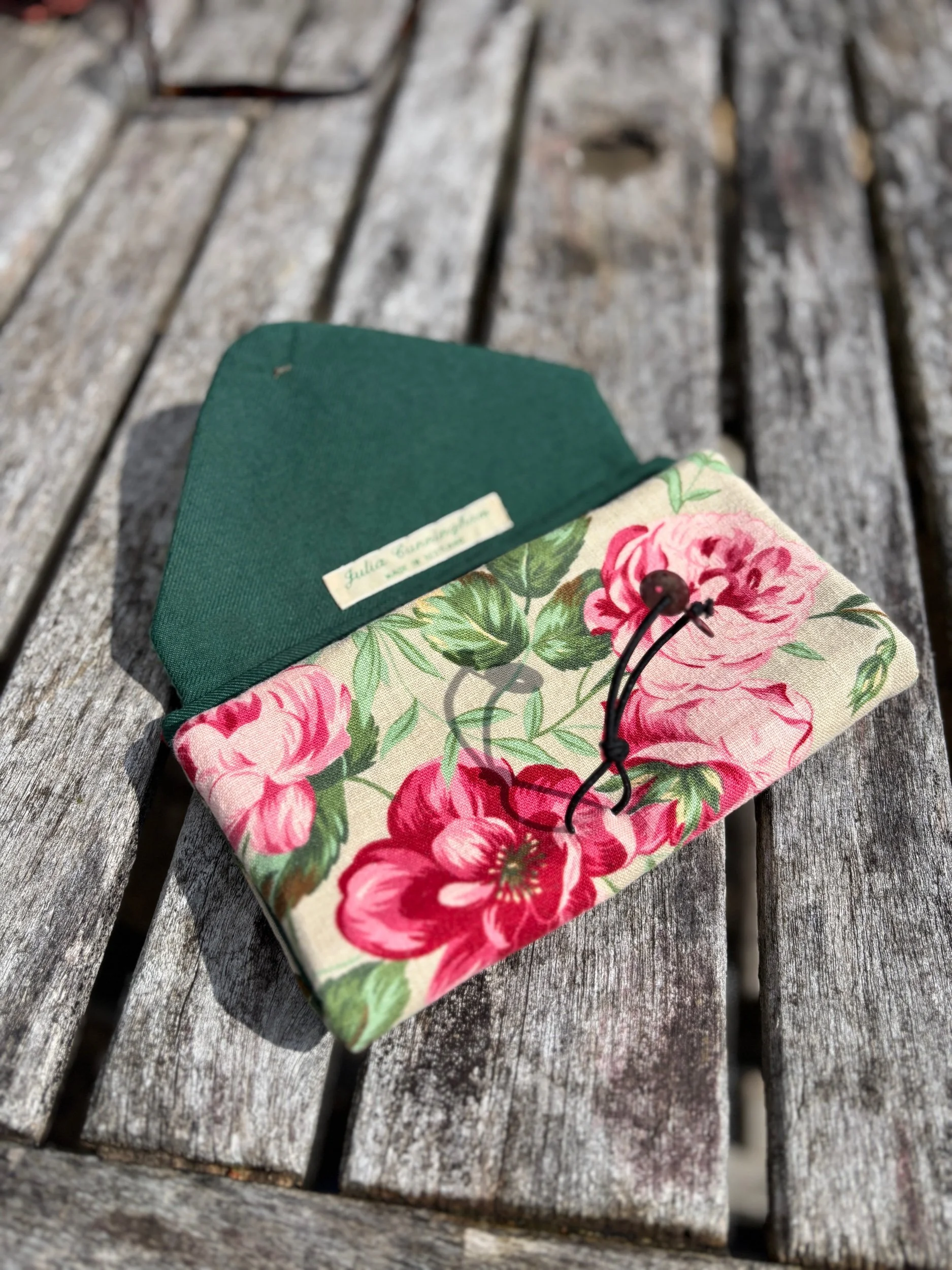 Close‑up of floral linen fabric texture on handmade upcycled clutch bag