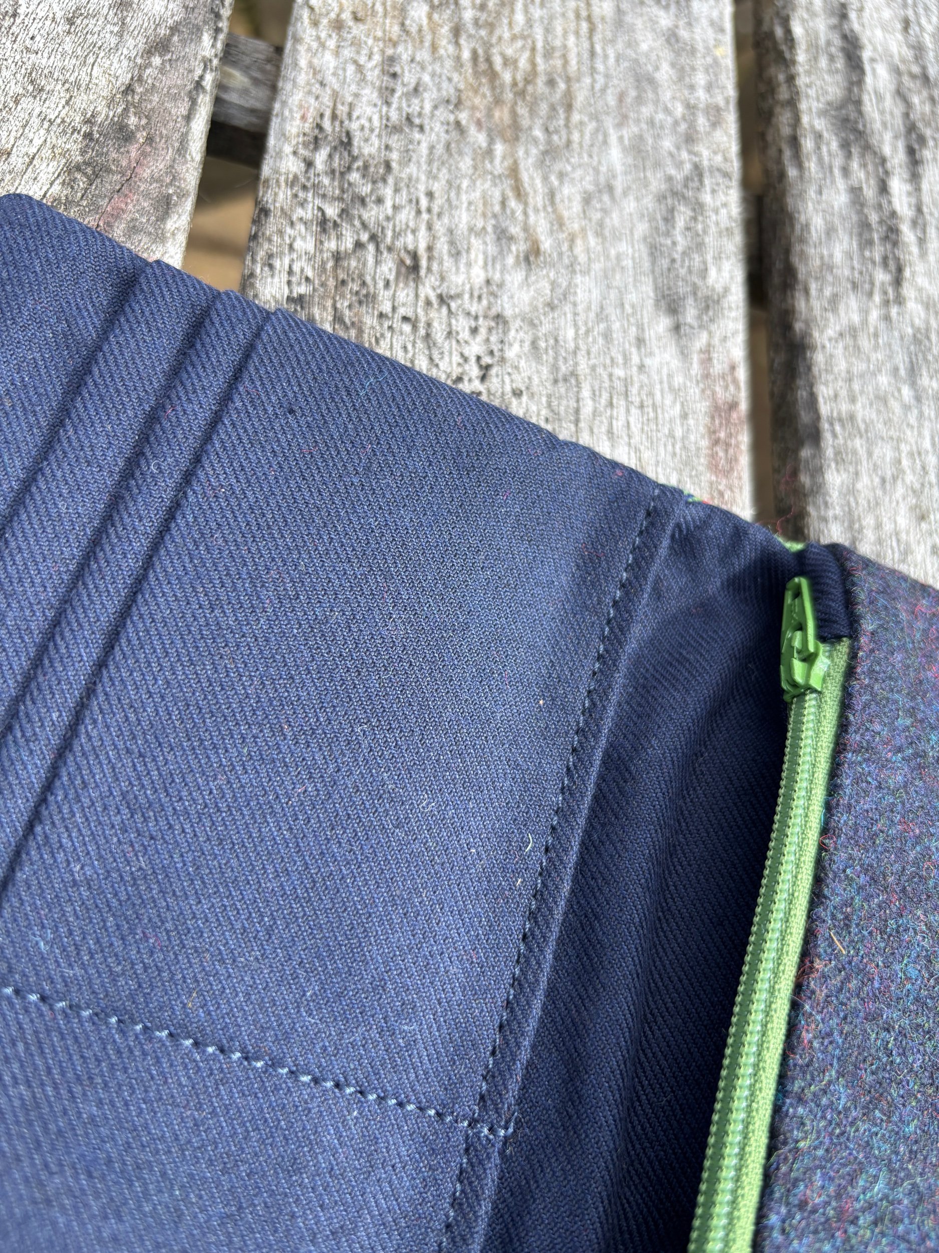 Close‑up of internal zip pocket on handmade tartan clutch bag, showing stitching and blue lining detail